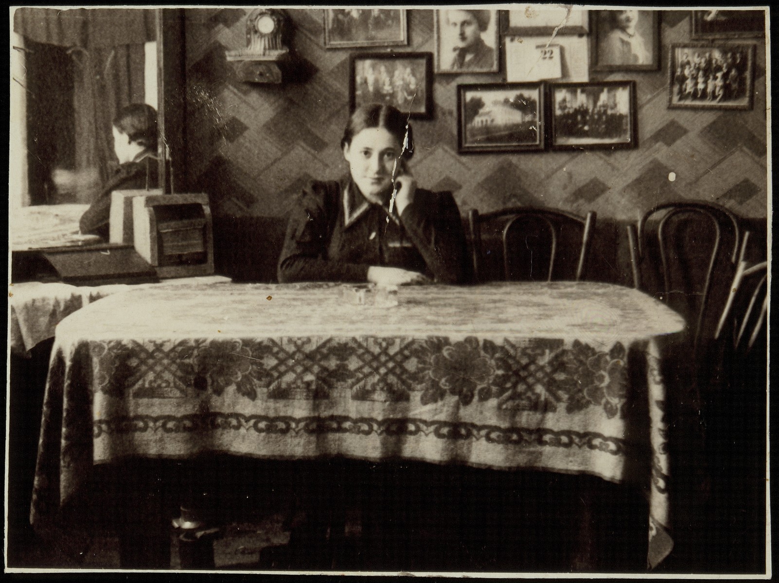 Rivka Pruskin Cofnas sits at a dining room table in the house of the photographer, Rephael Lejbowicz.