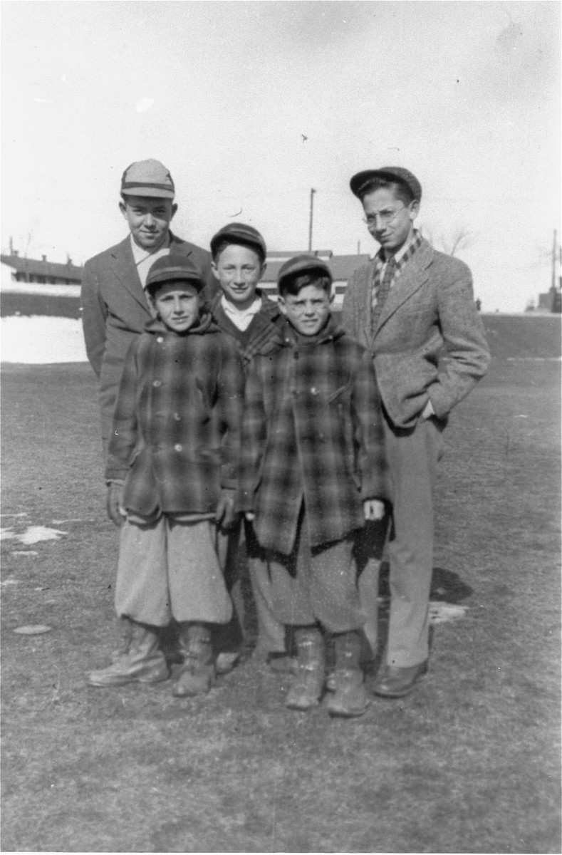 Group portrait of five boys living at the Fort Ontario emergency refugee shelter in Oswego, New York. 

Among those pictured are Leon Minz (first from the right) and Zigmund Krauthamer (standing in front of Minz).