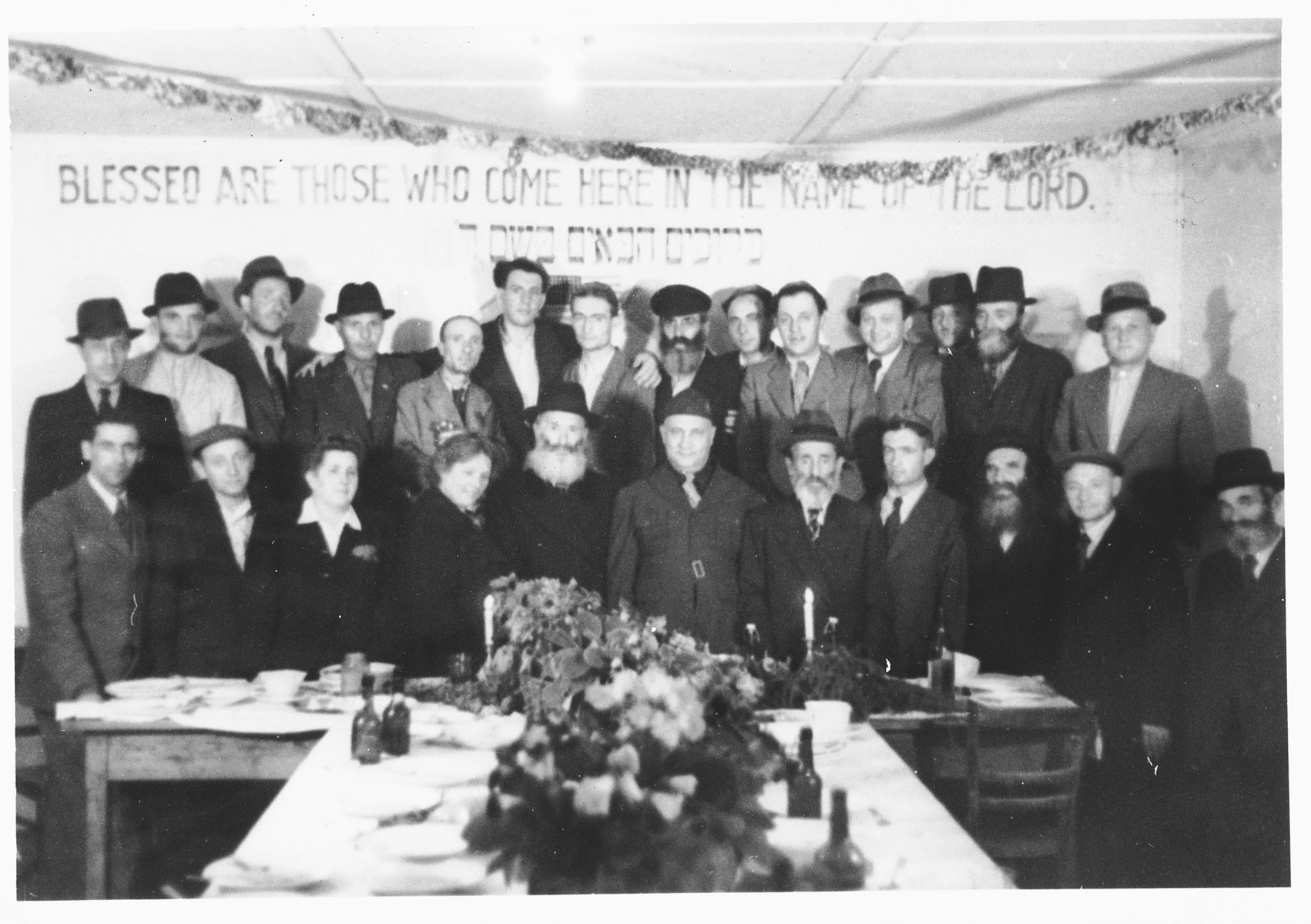 UNRRA camp director Harold Fishbein poses with a group of religious Jews at a holiday celebration in the Schlachtensee displaced persons camp.

Harold Fishbein is standing in the front row center, between the two bearded men.  Also pictured is Benjamin Holzer in the first row, on the far left.