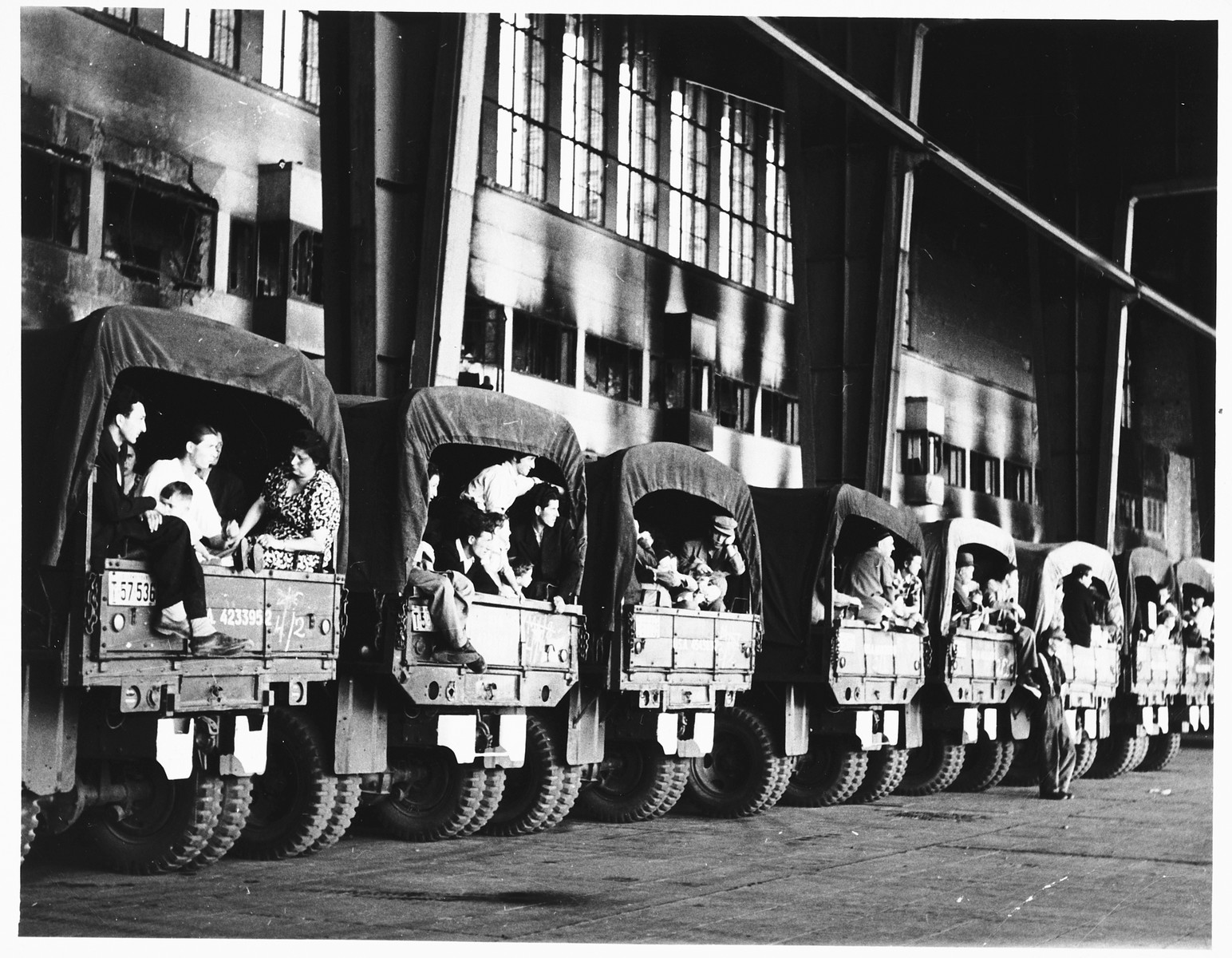 Canvas covered trucks packed with Jewish DPs [who are being evacuated to Frankfurt am Main during the Berlin Blockade] are parked in a row [probably at a Berlin airport].