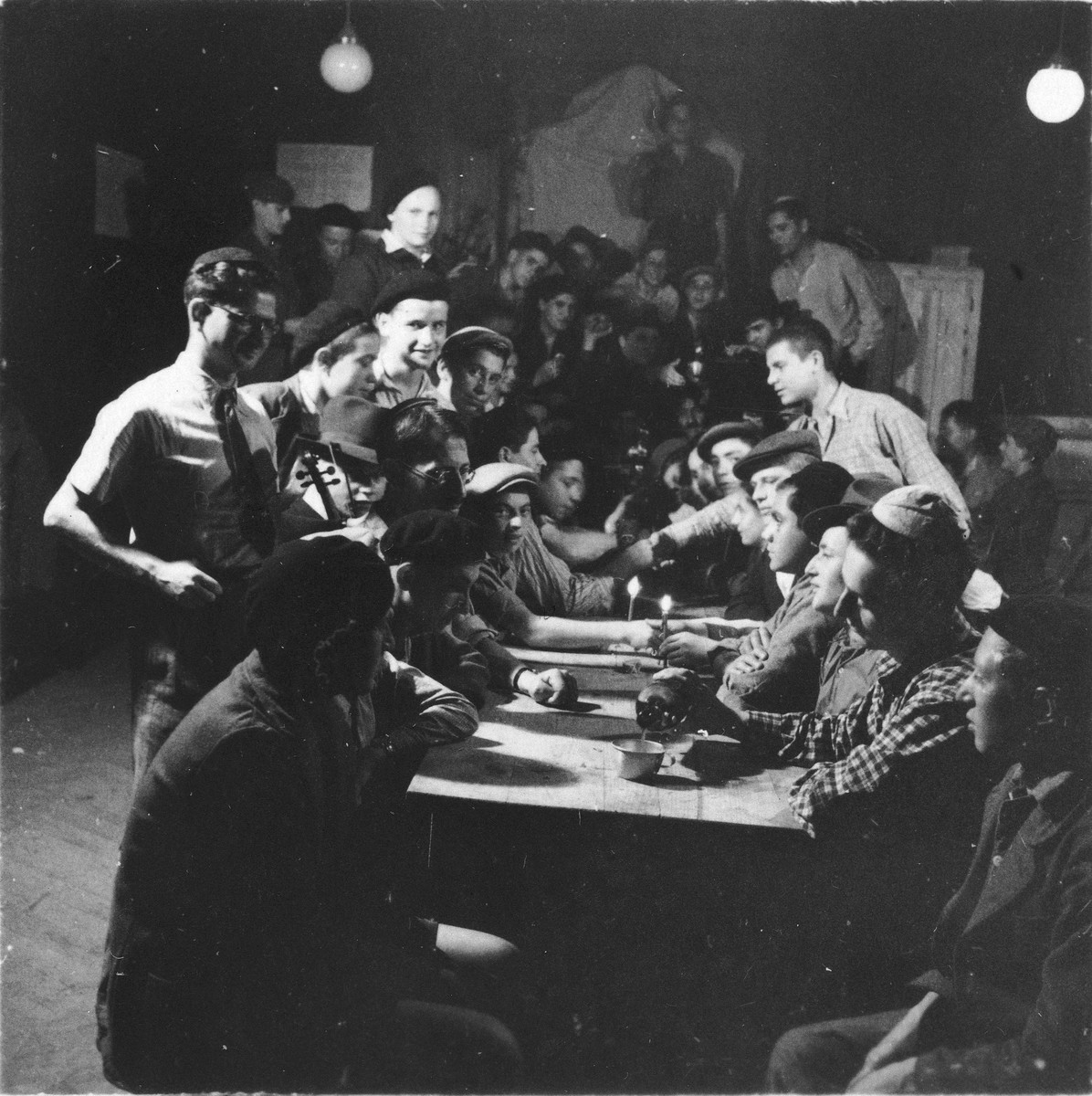 Jewish DP youth who numbered among the Buchenwald children, are gathered around a table at an OSE (Oeuvre de Secours aux Enfants) children's home in France [either in Ambloy or Taverny].