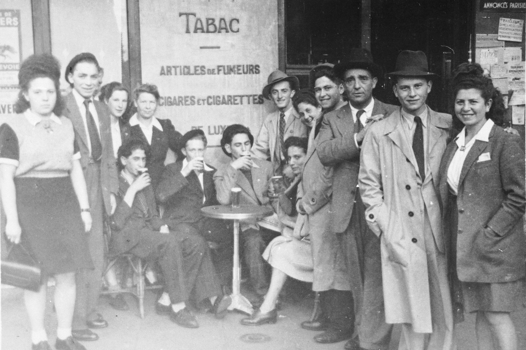 Jewish DP youth who numbered among the Buchenwald children, pose outside a tobacco shop near an OSE (Oeuvre de Secours aux Enfants) children's home in France [either in Ambloy or Taverny].
