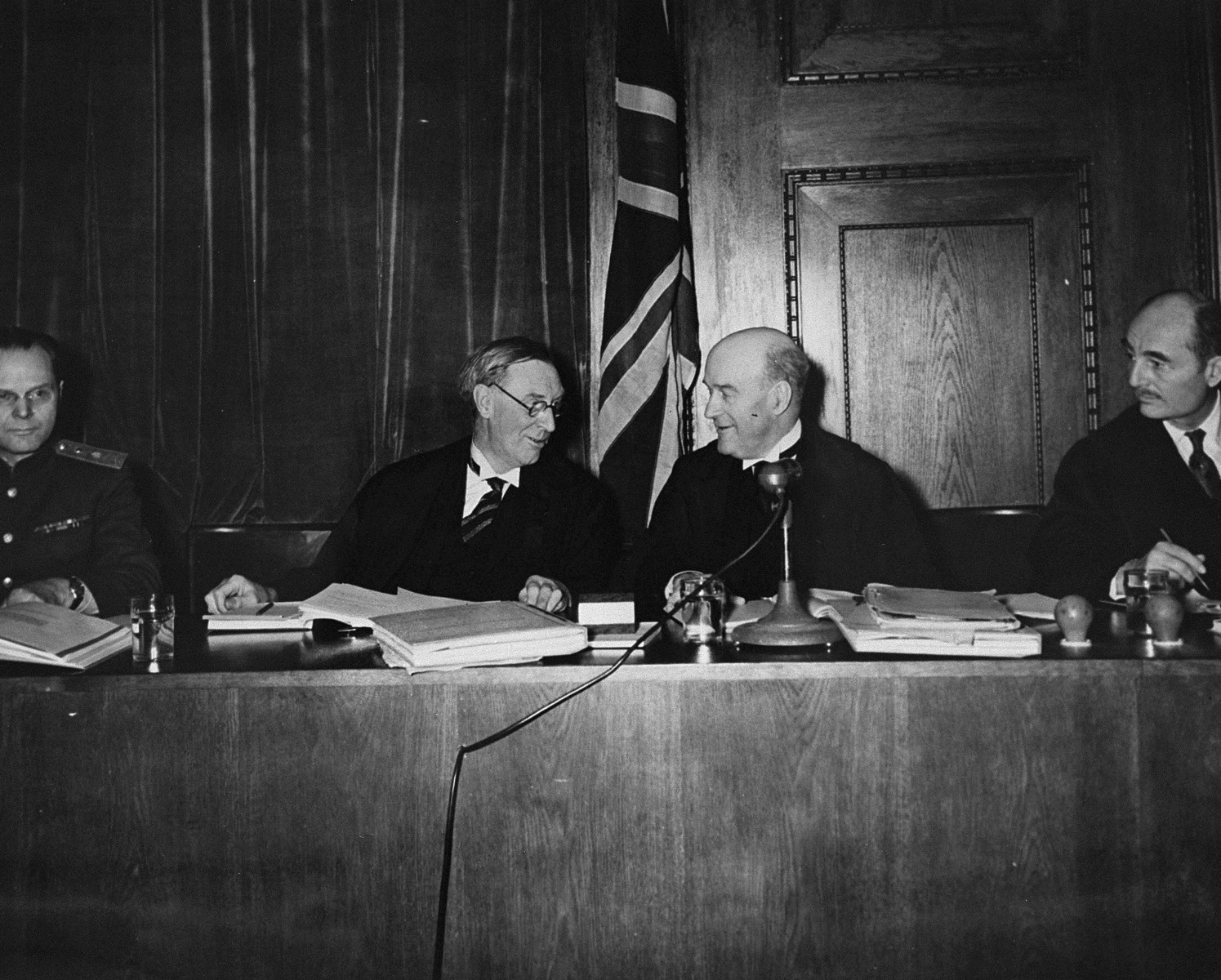 Four members of the International Military Tribunal sit on the bench in the courtroom in Nuremberg.

Pictured from left to right are: Major General I.T. Nikitchenko (Soviet), Justice Norman Birkett (British) Lord Justice Geoffrey Lawrence (British), and Francis Biddle (American).