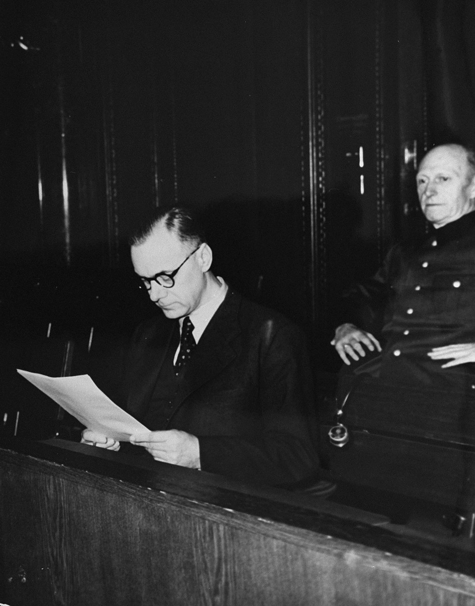Defendant Alfred Rosenberg, the former Chief Nazi Party ideologist, reads a document during the International Military Tribunal trial of war criminals at Nuremberg.  Behind him is his co-defendant General Alfred Jodl, formerly the Chief of Staff for the Army.