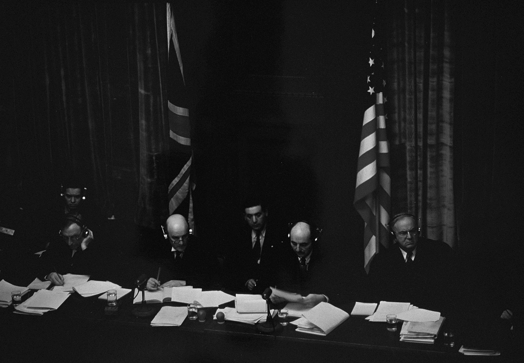 The British and American judges on the International Military Tribunal listen to testimony through their headphones at the trial of war criminals at Nuremberg.  

Pictured from left to right are: Justice Norman Birkett, Lord Justice Geoffrey Lawrence, Francis Biddle, and John J. Parker.