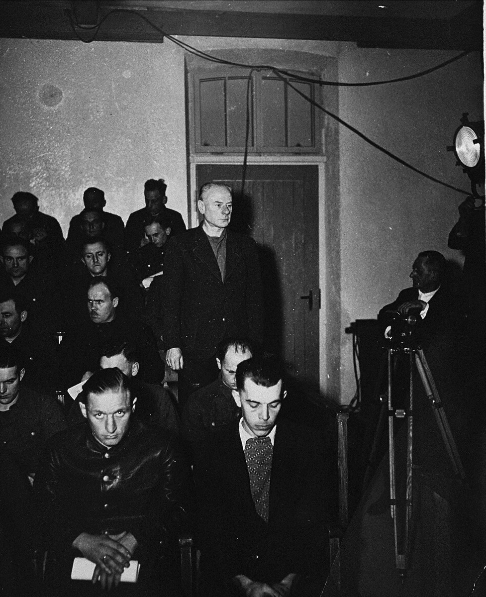 Dr. Eduard Krebsbach, a defendant at the trial of 61 former camp personnel and prisoners from Mauthausen, stands in his place in the defendants' dock.