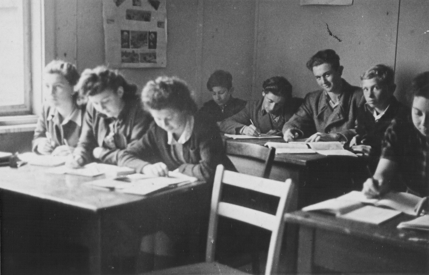 Jewish DP youth study in a high school classroom at the Schlachtensee displaced persons camp.  

Among those pictured is Regina Laks (front row, right).