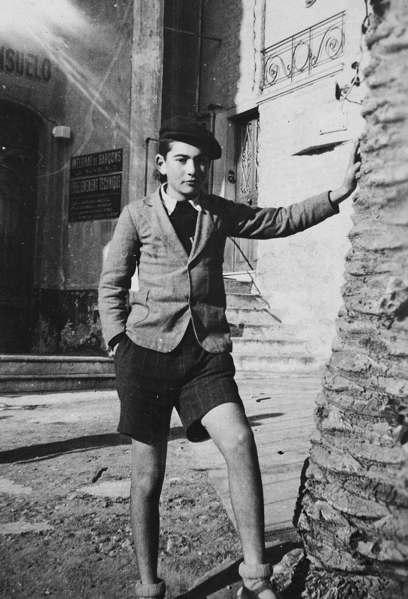 Paul Peter Porges, leans against  a palm tree on a street in Nice.