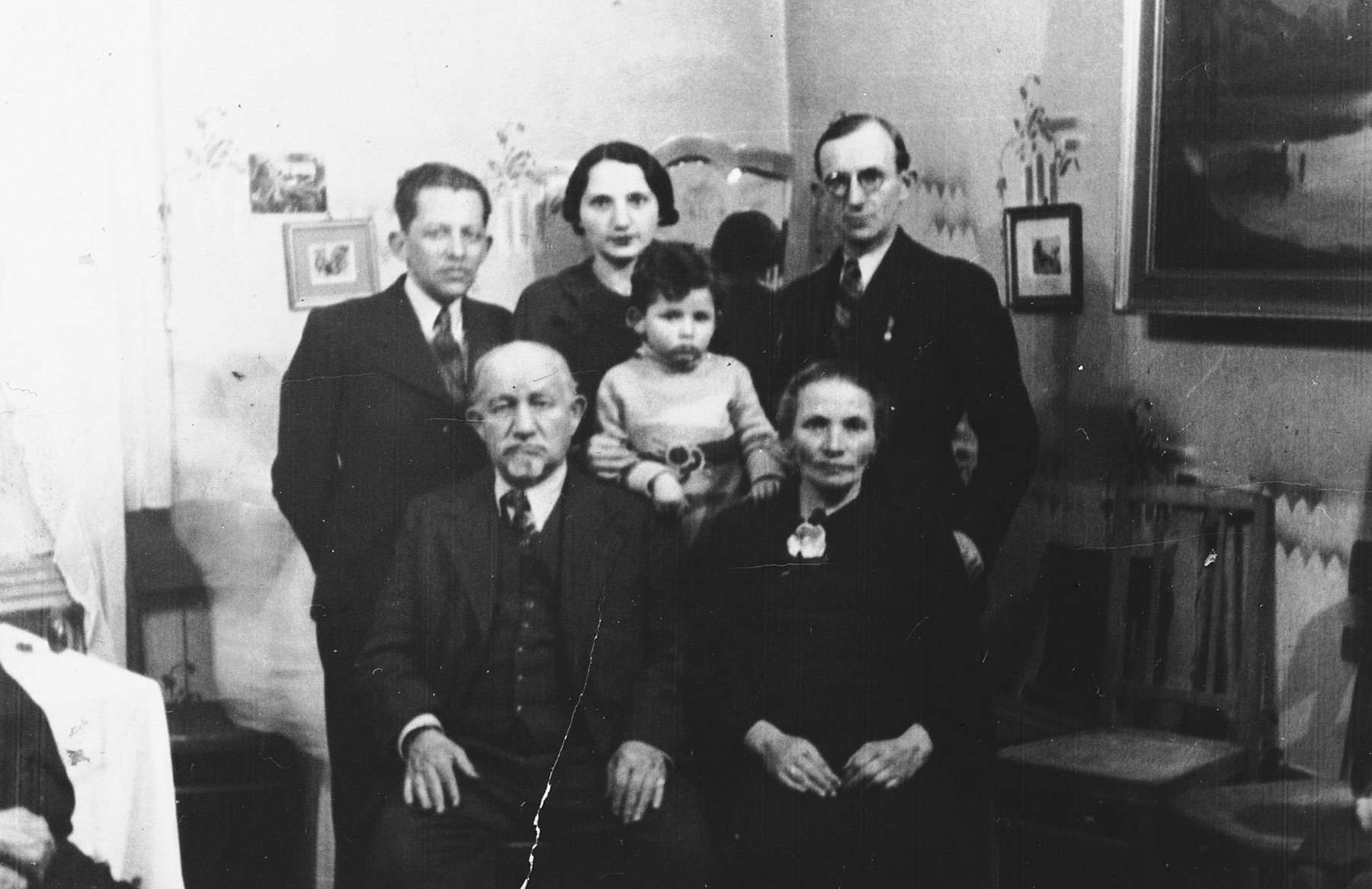 A Polish-Jewish family poses for a group portrait in their home.

Pictured are Leib and Mariam Adler; Schlameck Dunkelblau-Wintergreen; his wife, Erna Adler Dunkelblau-Wintergruen; her son, Jackie Dunkelblau-Wintergruen; and Herman Adler.  None of them survived.