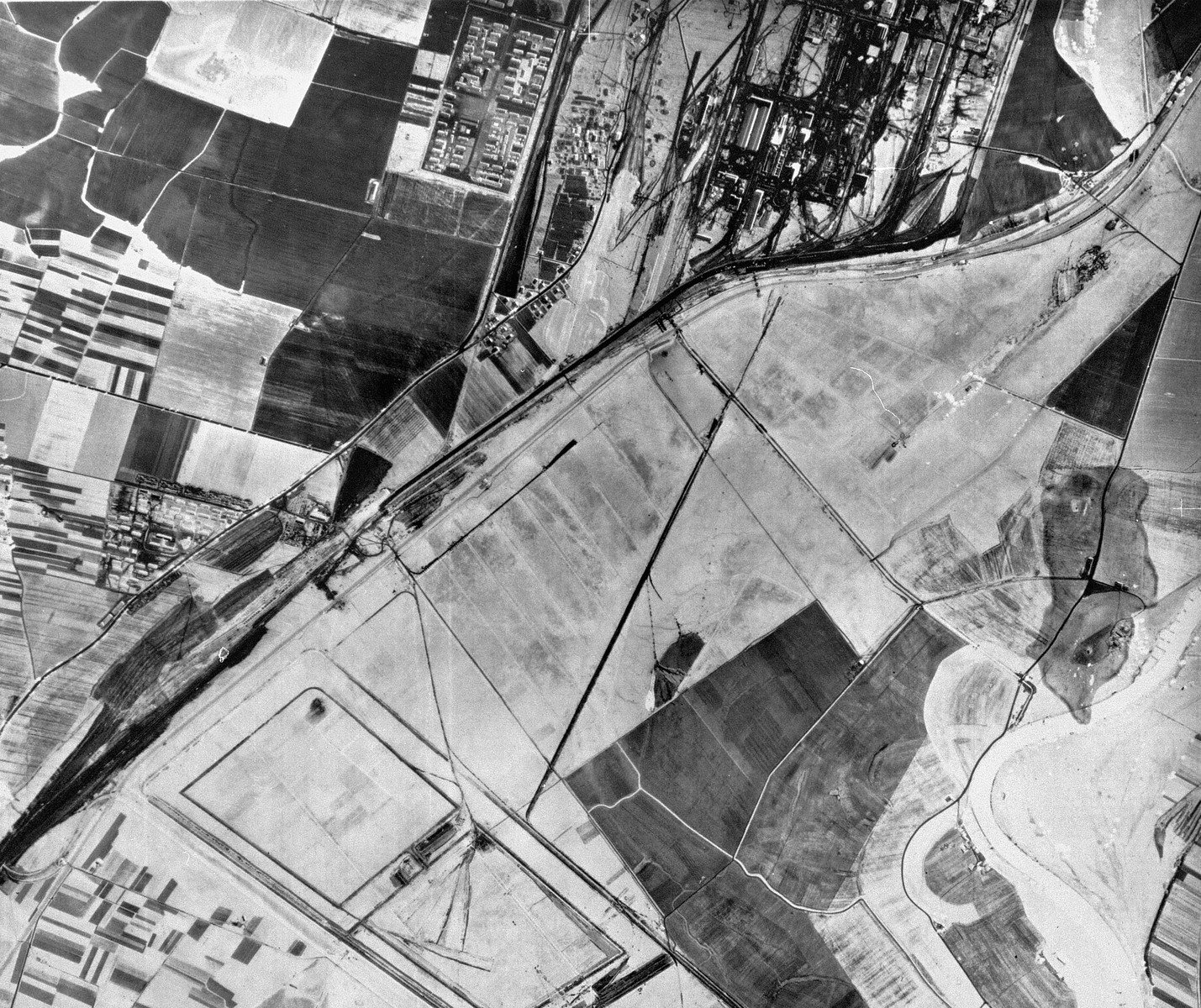 An aerial reconnaissance photograph of the Auschwitz area showing a partial view of the I.G. Farben "Buna" complex with the adjacent Monowitz (Auschwitz III).