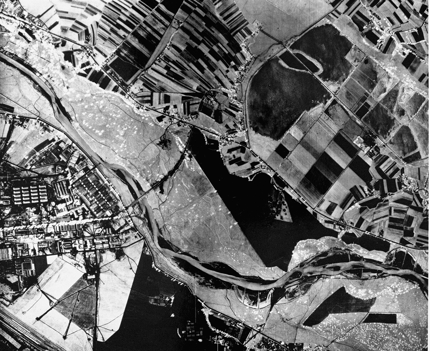 An aerial reconnaissance photograph of  Auschwitz I showing the administrative and living areas as well as the railway staging area in the upper corner.