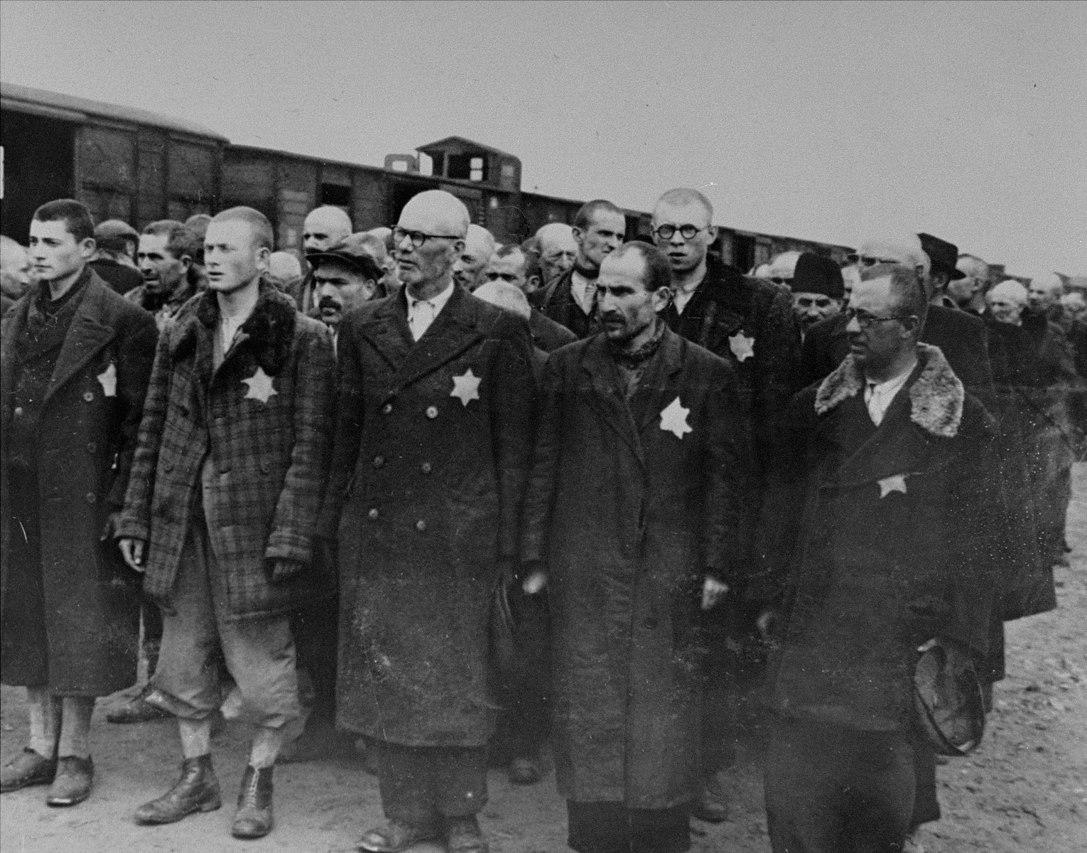Jews from Subcarpathian Rus who have been selected for forced labor at Auschwitz-Birkenau, wait to be taken to another section of the camp.