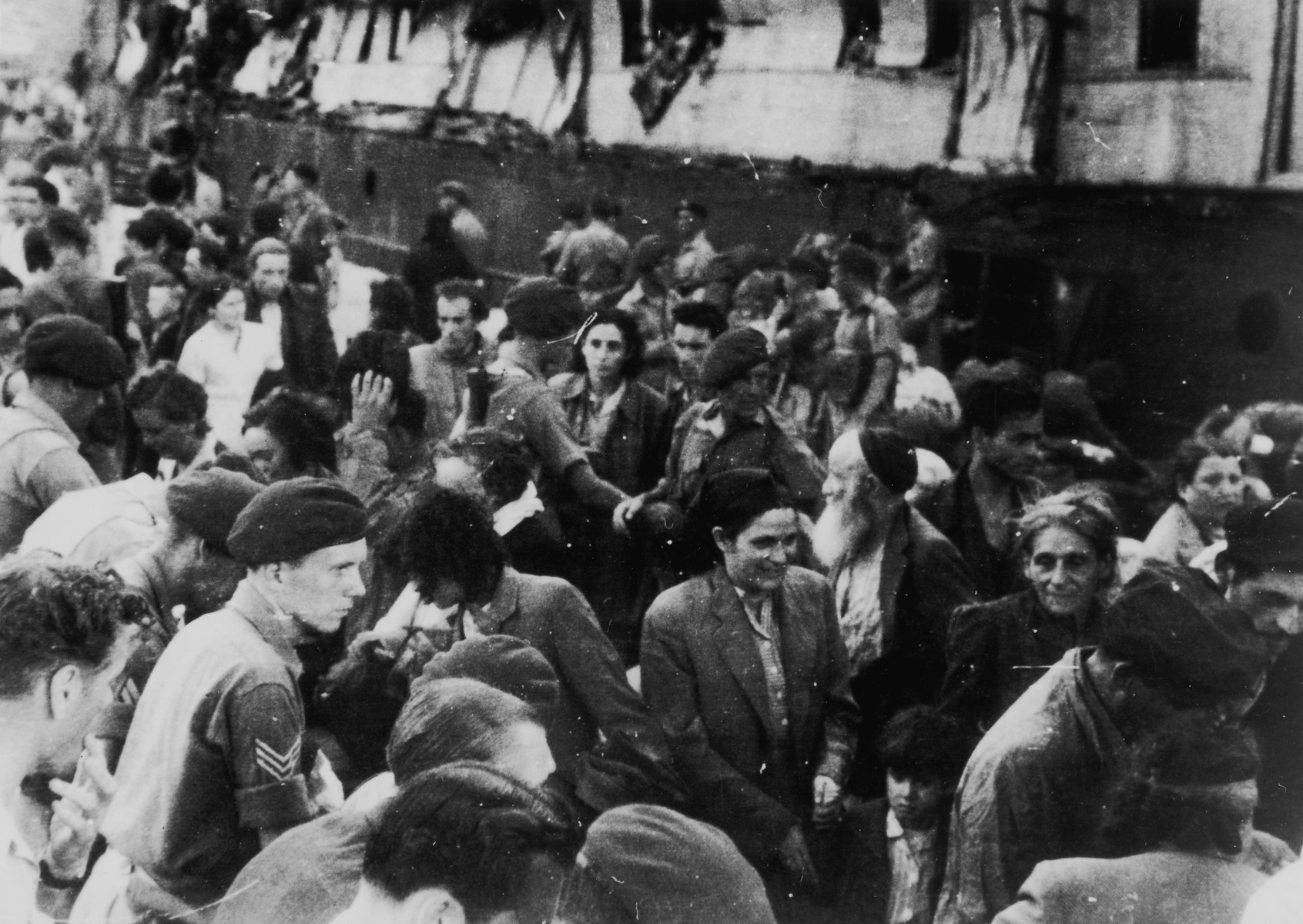 Passengers from the illegal immigrant ship, Exodus 1947, are guided by British soldiers into line to have their papers checked on the dock in Haifa harbor.