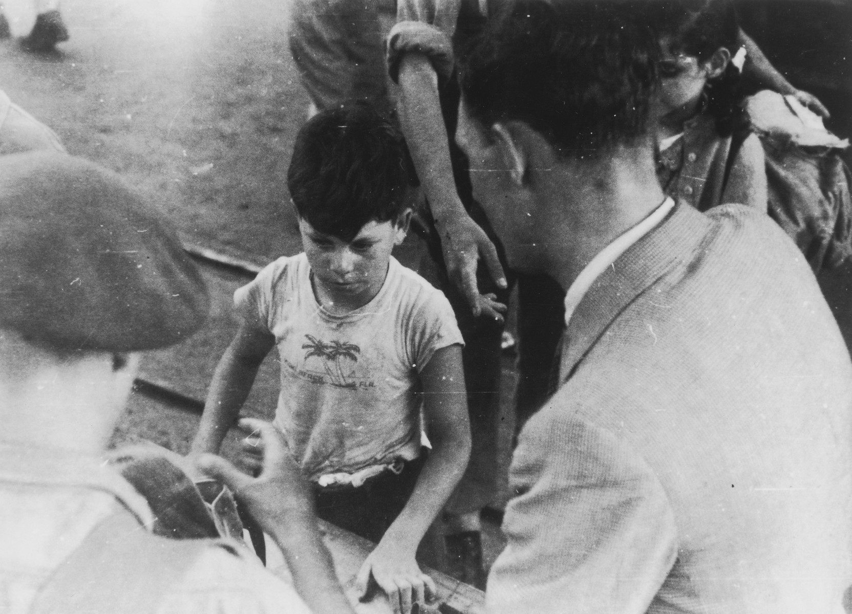 A young Jewish boy, who is one of the passengers on the illegal immigrant ship, Exodus 1947, has his papers checked by a British soldier on the dock in Haifa.