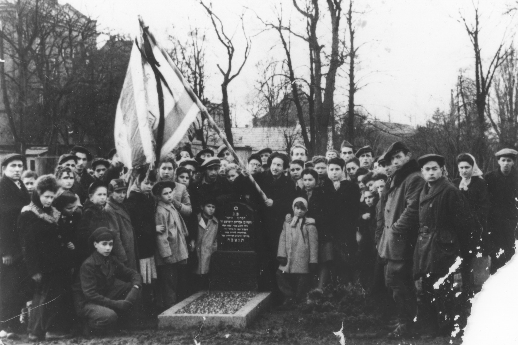 Former passengers on the Exodus 1947 gather around the grave of a comrade who died.  

The grave is that of Moshe Kiperbus, who died December 19, 1947, at the age of 17.
