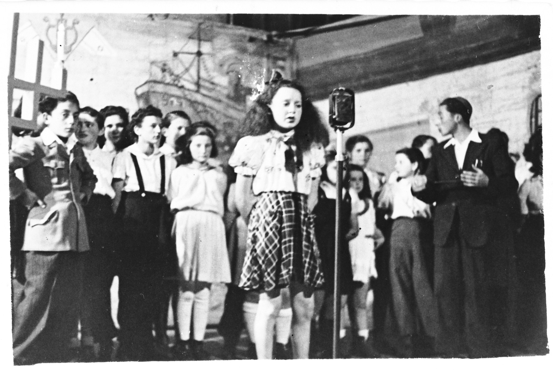 Performance by the children's choir of the Hebrew Tarbut school in the Foehrenwald displaced persons camp.

Among those pictured is Yasha Einstein (far left).