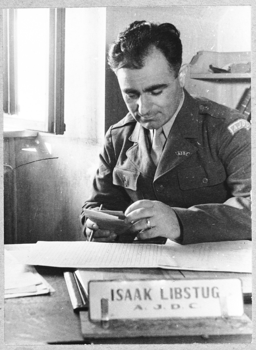 JDC director, Isaak Libstug works at his desk in the Foehrenwald displaced persons camp.