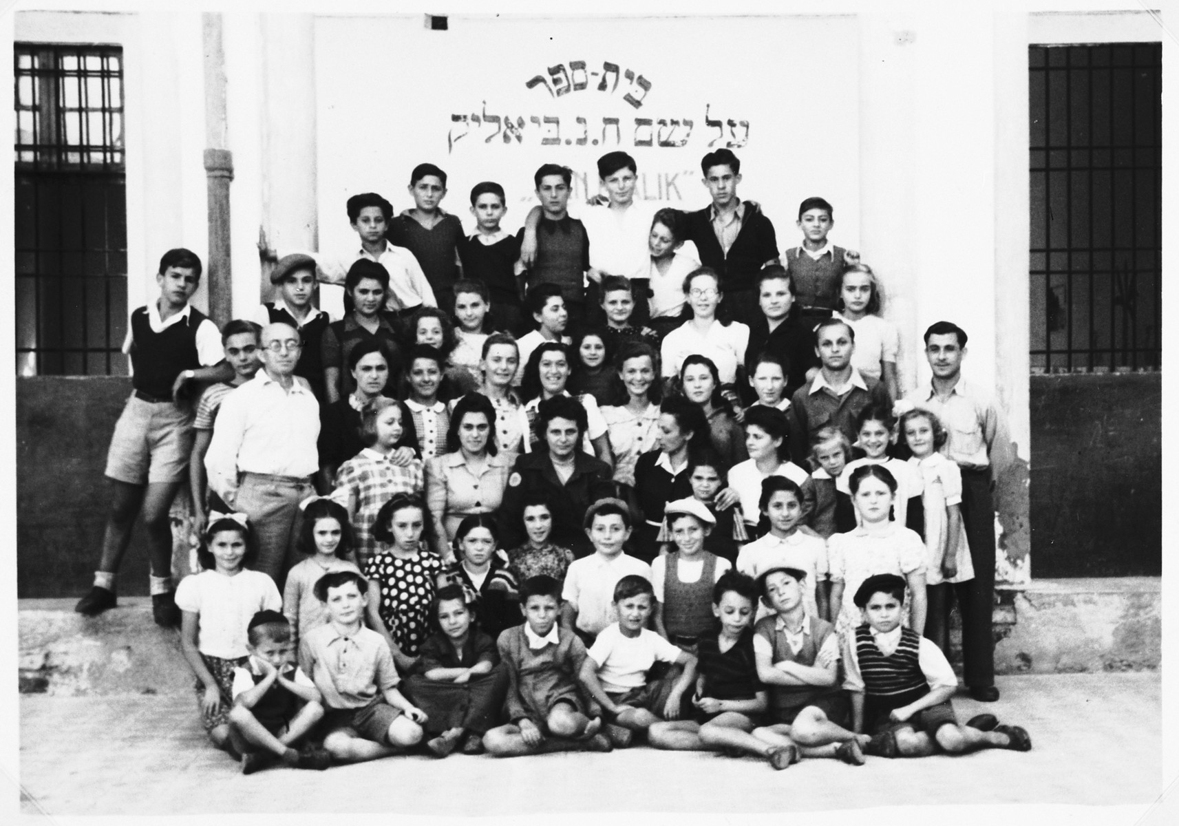 Students and teachers in the Bialik Hebrew school in the Cremona DP camp.

Those pictured include the teacher, Motel Bass (far left, in white shirt), Feige Truszinski, Chaya Truszinski, Shmuel Unger, Shie Zoltak, Luba Klot, Raizel Grinszpan, and Ernst Schnittlinger (behind teacher), Lea Schnittlinger (third row from bottom weating plaid dress), Esther (Grinberg) Abrams (third row from bottom, second from left, in light-colored dress) Josephine and Alexander Schnittlinger (far right, top two rows), and Selig Tabak (fourth row, second from the right). Basia Eisenberg is seated in the second from, third from the left. Sunja Kaufman is standing in the back row on left (wearing dark shirt).