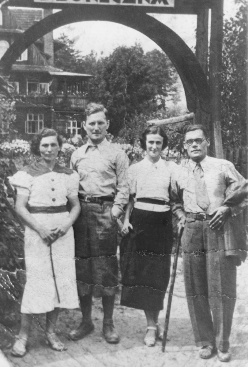 Two Jewish couples pose beneath an arch in the resort town of Krynica.

Pictured on the left are Heniek and Cesia (Merin) Szyniarowski.  On the right are two unidentified friends.  Heniek and Cesia perished in Auschwitz in 1943.