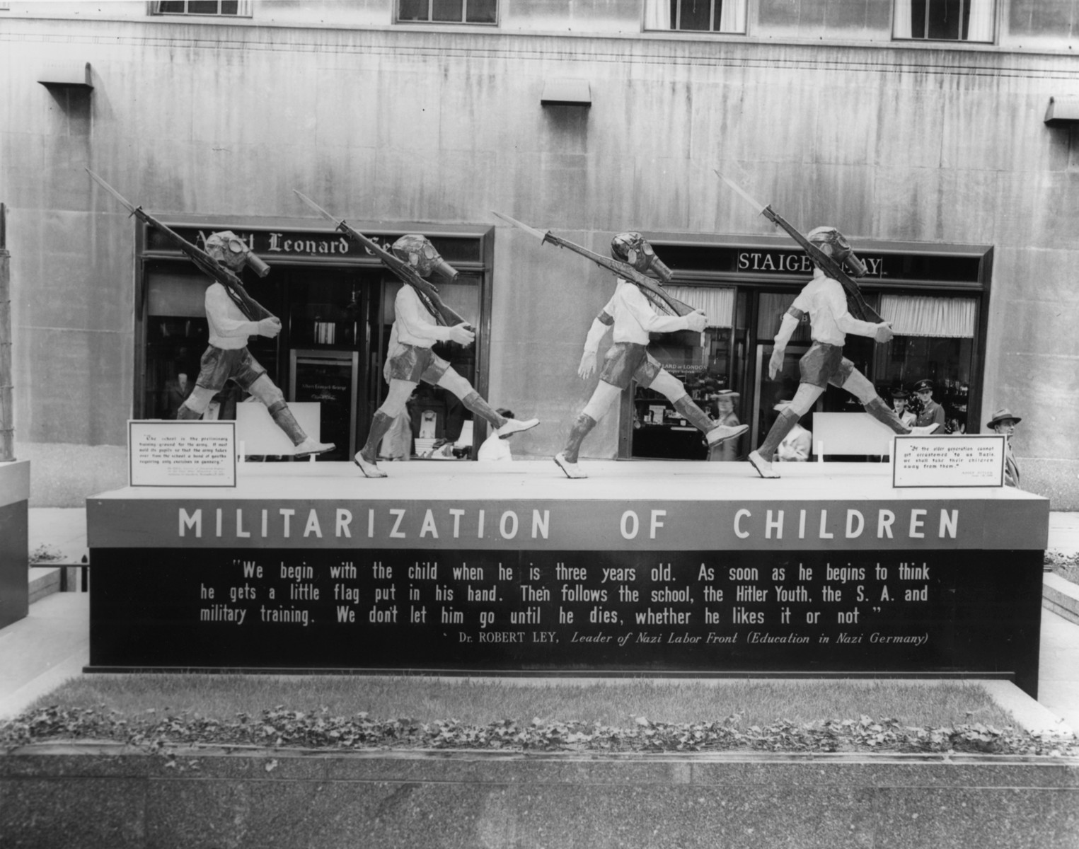 View of the tableau entitled "Militarization of Children" part of the  "The Nature of the Enemy" exhibition at Rockefeller Plaza in New York city.  

The display depicts the enemy's conception of a child's education.
