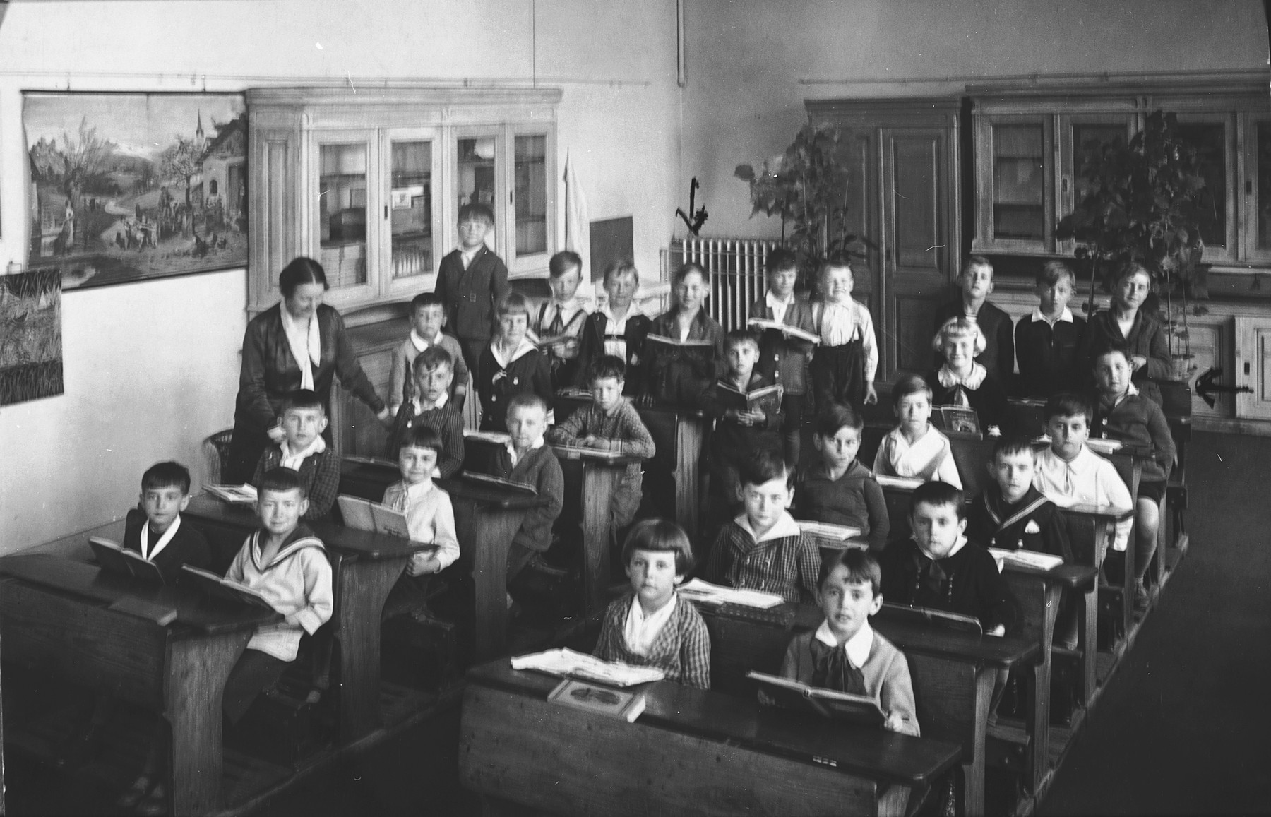 Pupils in the first grade sit in their classroom at a public school in Prague.  Among the students are several Jewish children.

Among those pictured are Edgar Krasa (back row, left) and Max Widder (second to last row, right side).