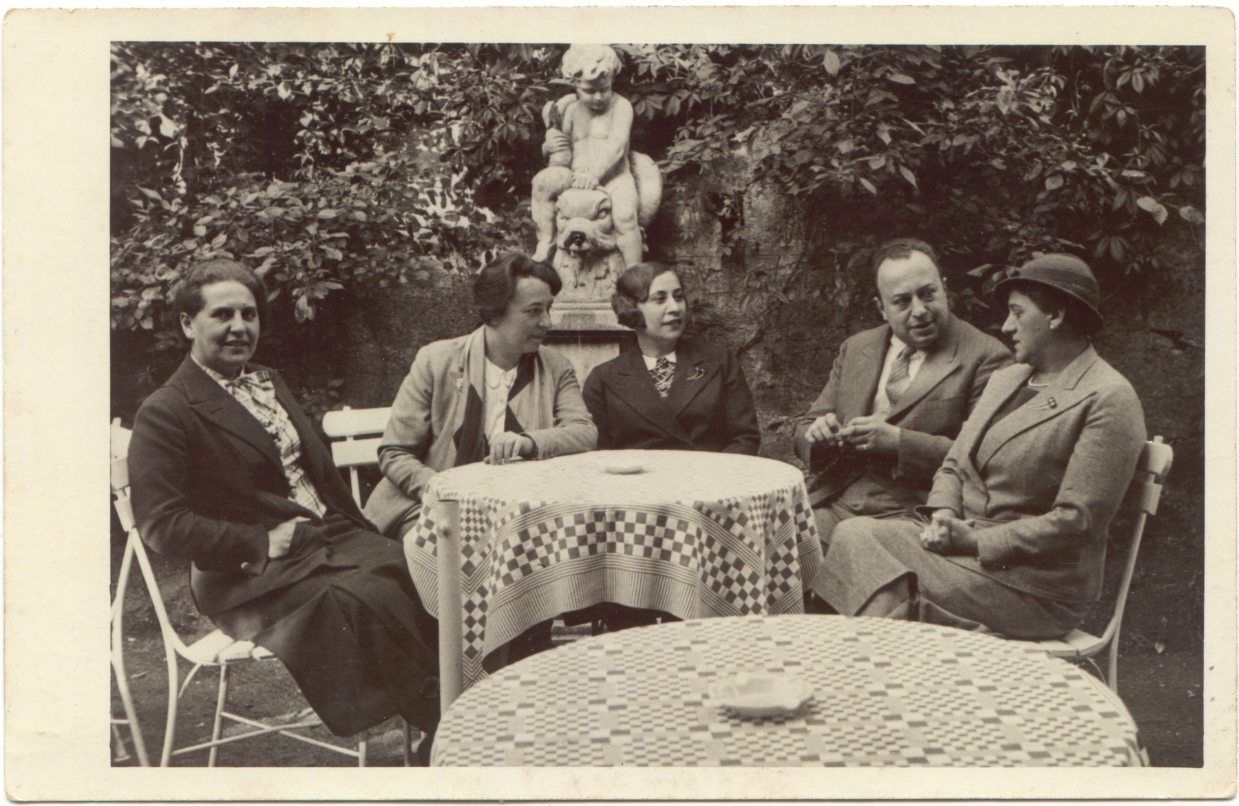 A German Jewish family sits around an outdoor table.

From left to right: ?. Lidi Gruenthal Dzialowski, Gerta Gruenthal, Adolph Gruenthal, and Bertha Gruenthal.