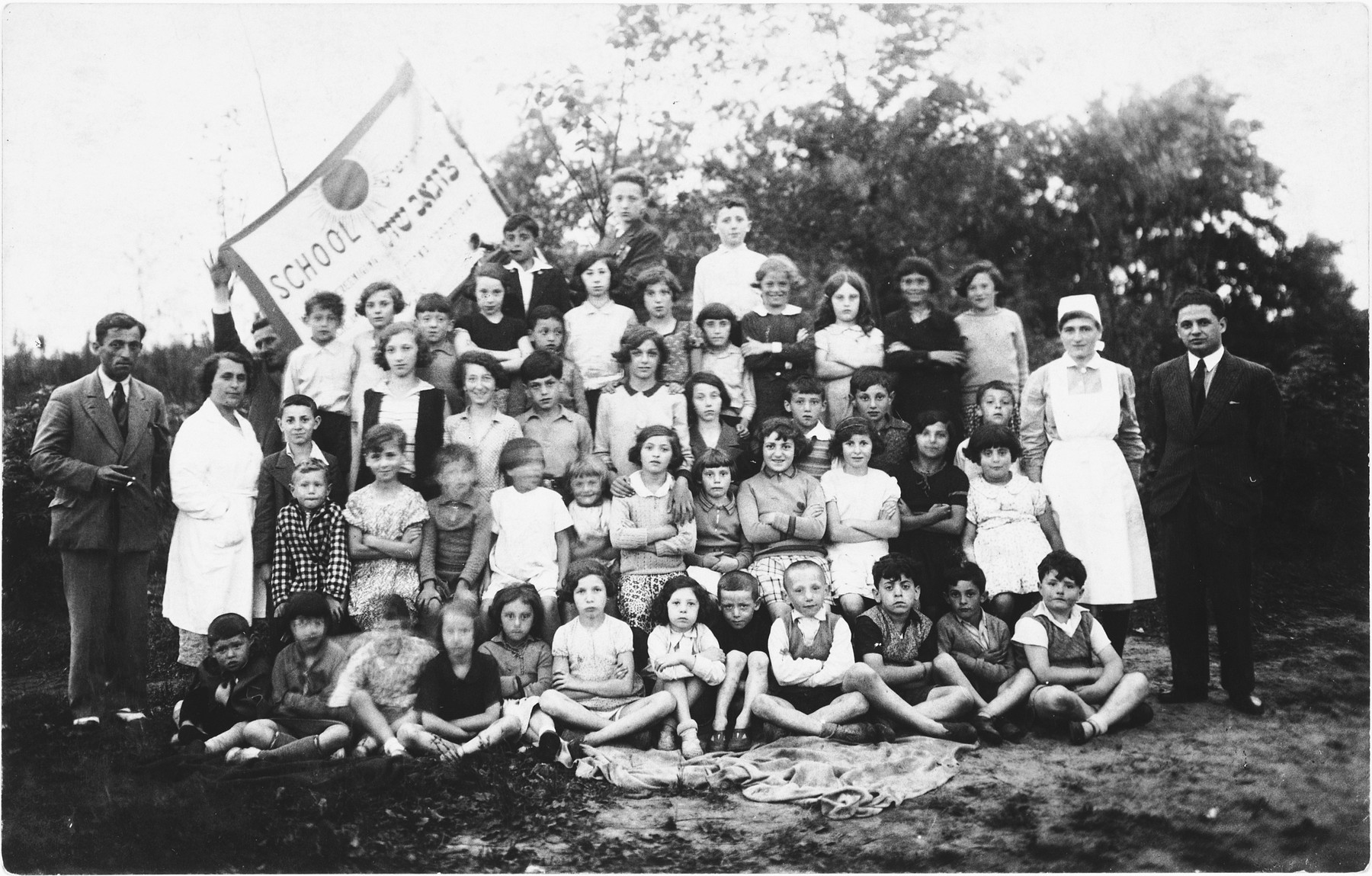 Group portrait of the children and faculty of the Jewish Zugob school, sponsored by the Jewish Artisan Association.

Among thos pictured is Lea Rubinstein, standing in the back row, right.