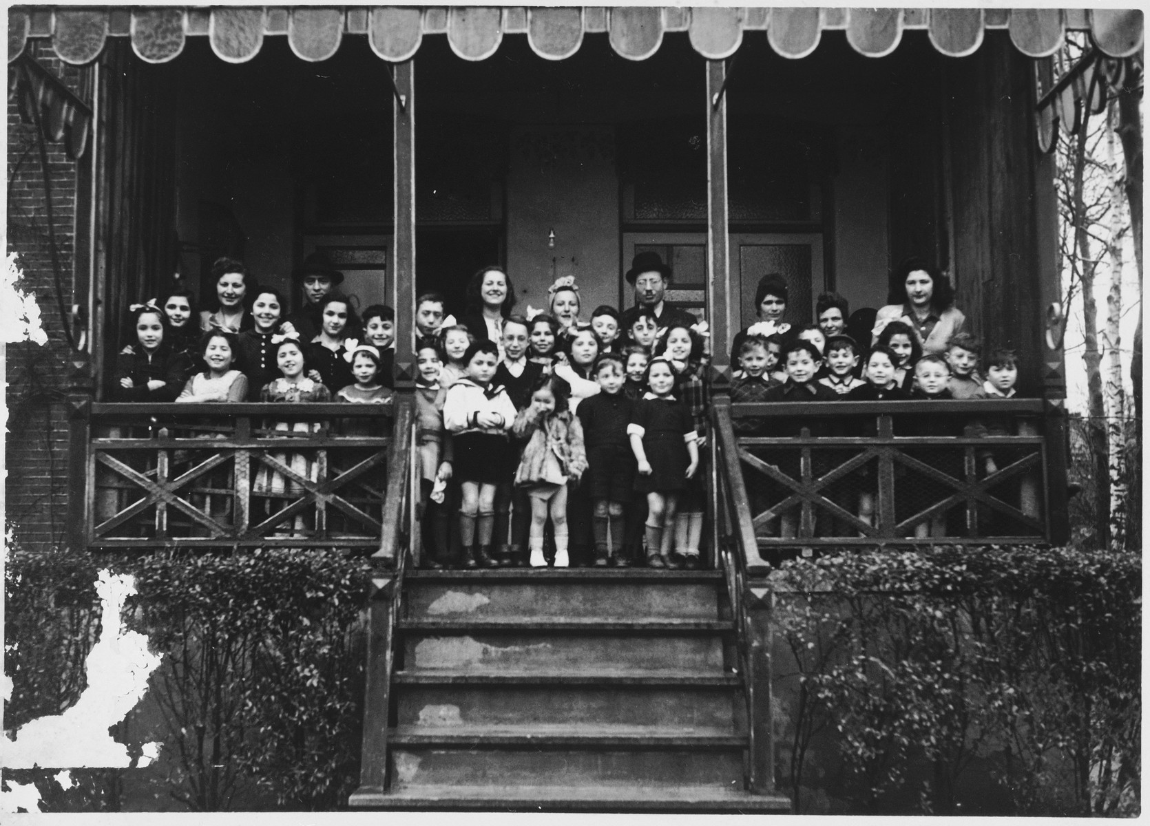 Group portrait of the children and staff of the Mariaburg DP children's home near Antwerp.

Among those pictured are Jonas and Ruth Tiefenbrunner. To their left is another teacher, Miriam Zupnick.  In front is their daughter Jannette.
