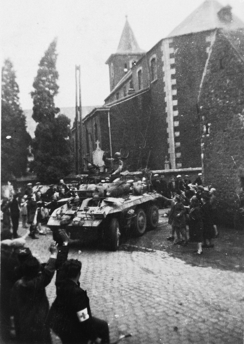 Belgians wave to an American tank as it liberates the town of Liege.