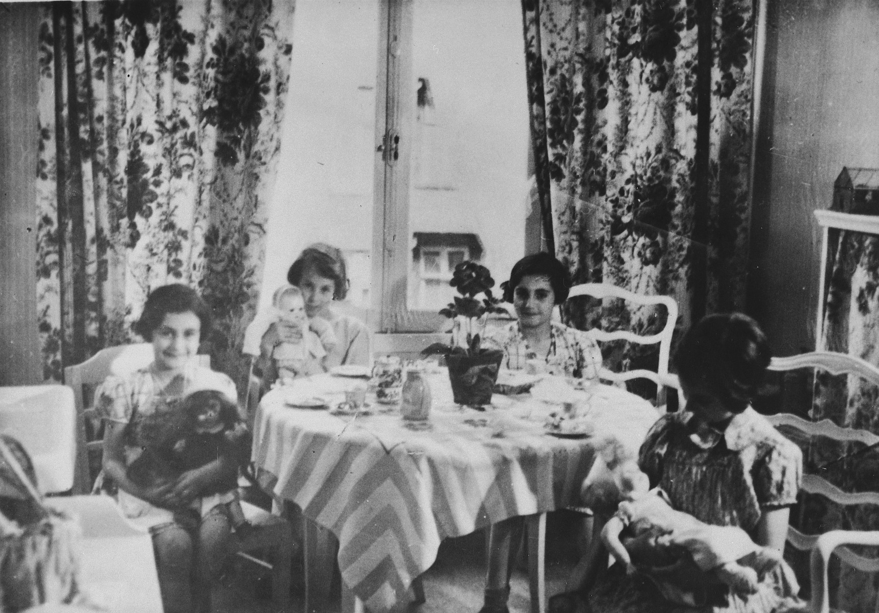 Four young girls from Germany, including Anne and Margot Frank, have a tea party with their dolls at the home of Gabrielle Kahn in Amsterdam.

Pictured from left to right are Anne Frank, Ellen Weinberger, Margot Frank and Gabrielle Kahn.