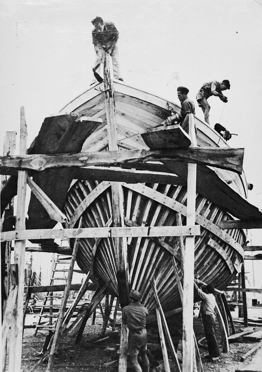 Jewish DPs build a new fishing boat at the Migdalor hachshara, a maritime Zionist collective in Fano, Italy.