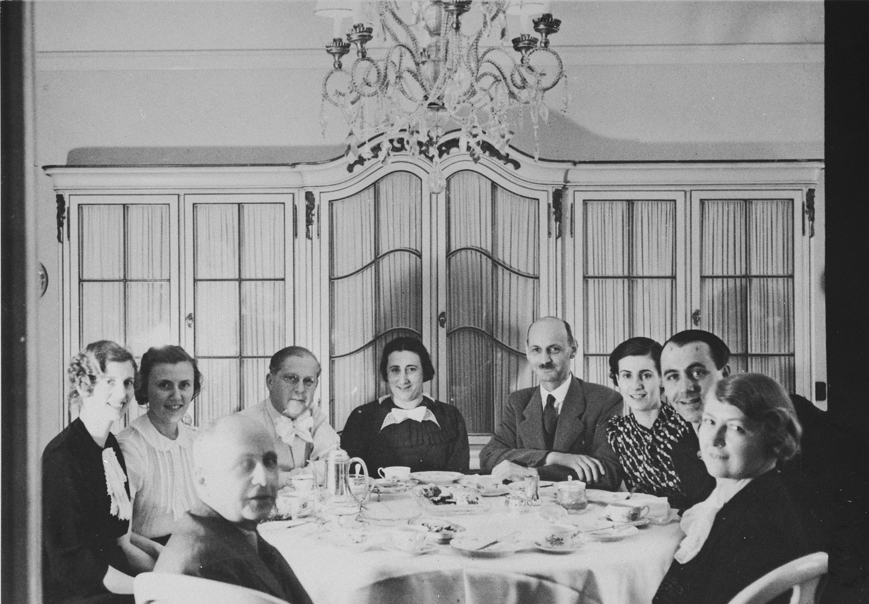 Jewish friends who have met for tea, including the parents of Anne Frank, pose around a table in a private home in Mannheim, Germany, shortly before many of them fled the country as refugees of the Nazi regime.

Pictured seated clockwise, from the front left, are Otto Kahn, Hildegarde (Koppel) Weinberger (sister of Annelies Kahn), Irene Kaufer, Dr. Richard Kahn, Edith Frank, Otto Frank, Annelies Kahn, (mother of Gabrielle Kahn and sister-in-law of Hildegard Weinberger) and two undidentified individuals.
