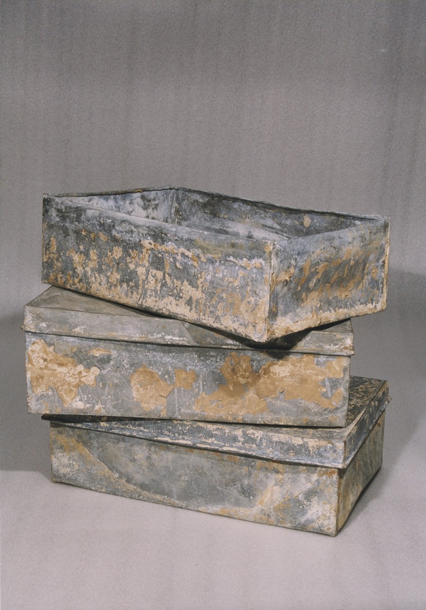 Three of the ten metal boxes in which portions of the Ringelblum Oneg Shabbat archives were hidden and buried in the Warsaw ghetto.  The boxes are currently in the possession of the Jewish Historical Institute in Warsaw.  In this view the boxes are piled on top of one another.  The box on top is displayed without the lid.