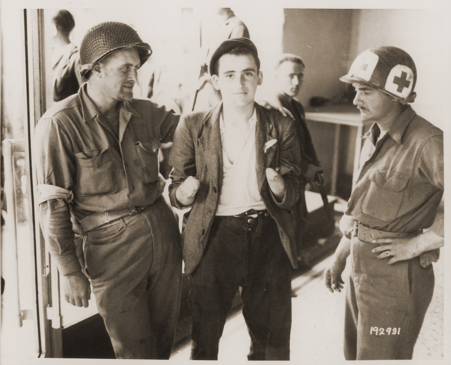 A French resistance fighter, whose hands were cut off by Germans, receives medical attention from U.S. Army medics.