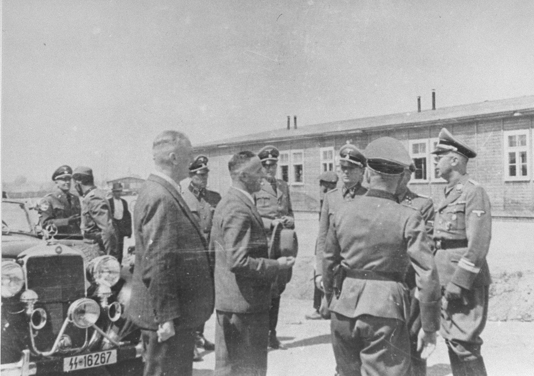 Reichsfuehrer SS Heinrich Himmler converses with Max Faust (holding the fedora) during a tour of the Monowitz-Buna building site.

Faust, who was an IG Farben engineer, was the head of building operations at Monowitz-Buna.