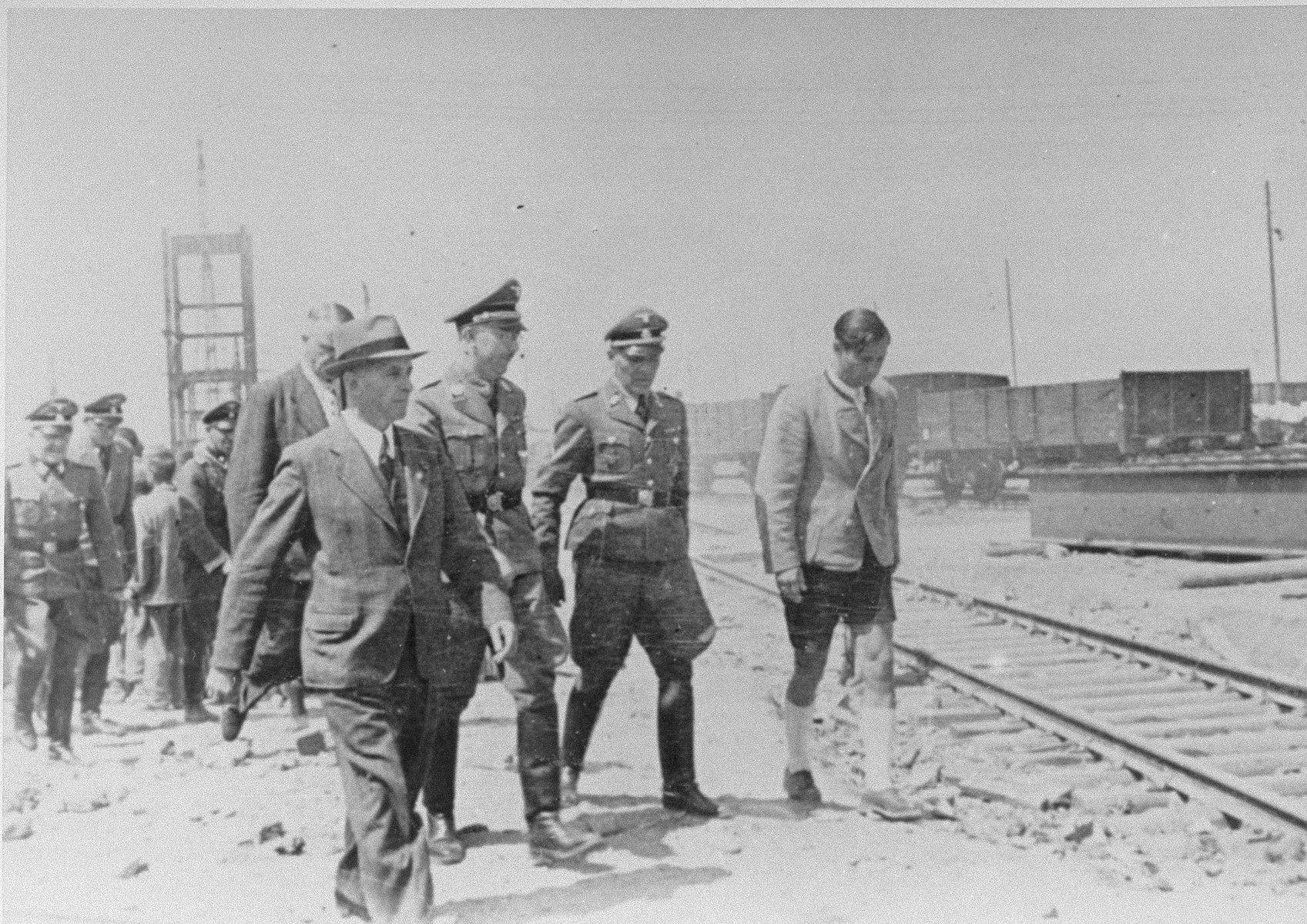 Reichsfuehrer SS Heinrich Himmler tours the Monowitz-Buna building site in the company of Max Faust (wearing the fedora) and Auschwitz commandant Rudolf Hoess (second from the right in the first row). 

Faust, who was an IG Farben engineer, was the head of building operations at Monowitz-Buna.