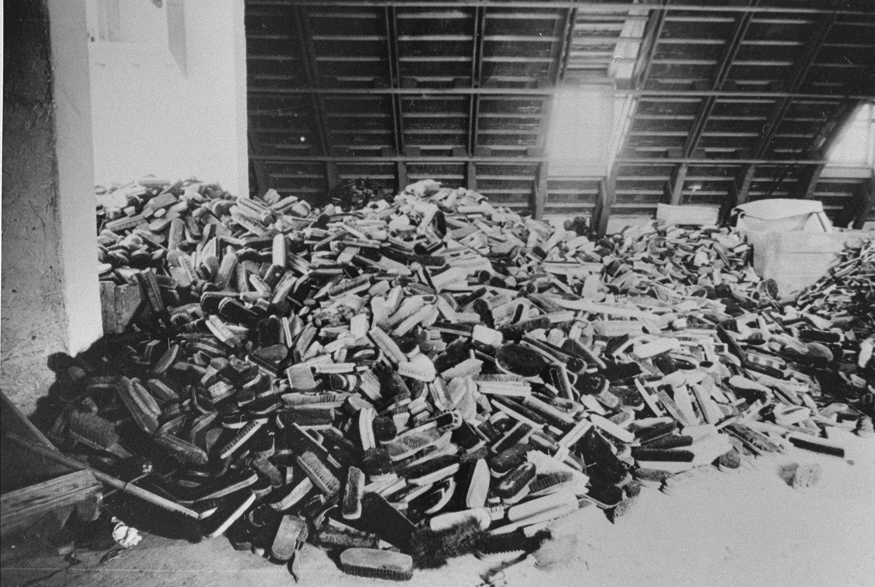 A large pile of brushes, that were confiscated from arriving prisoners, are stored in one of the "Canada" warehouses in Auschwitz.