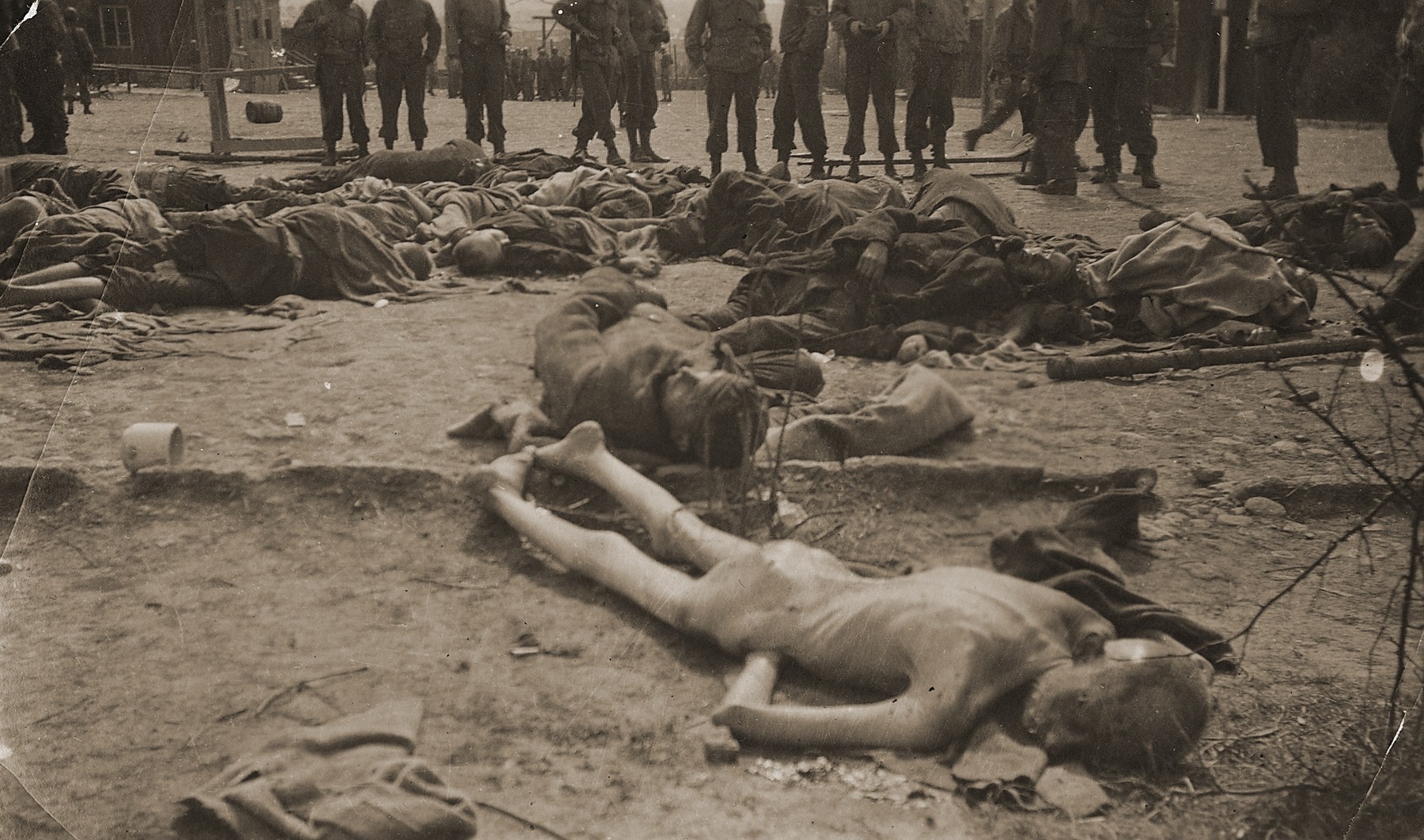 American soldiers view the bodies of prisoners shot by the SS during the liberation of the camp.