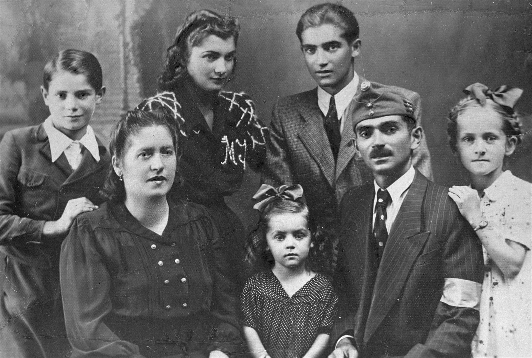 Studio portrait of the Markovits family in Cluj.  

Pictured in the front row (left to right) are: Irena, Eva, David, Ilonka; in the back row (left to right) are: Simon, Jolanda and Andre (the donor).

The photo was taken on the occasion of the visit by David Markovits, who had been allowed a one-day leave from his Hungarian labor brigade unit.  Immediately upon his return to the labor brigade, he was deported to Dachau.  David was liberated in Dachau, but died a short time after, on June 20, 1945.

The donor, Andre Markovits, who was liberated from Buchenwald, returned to Cluj after the war and retrieved this photo from the photographic studio in which it was taken in 1943.  Andre was the sole survivor of his family, who were all deported from the Cluj ghetto to Auschwitz in April, 1944.