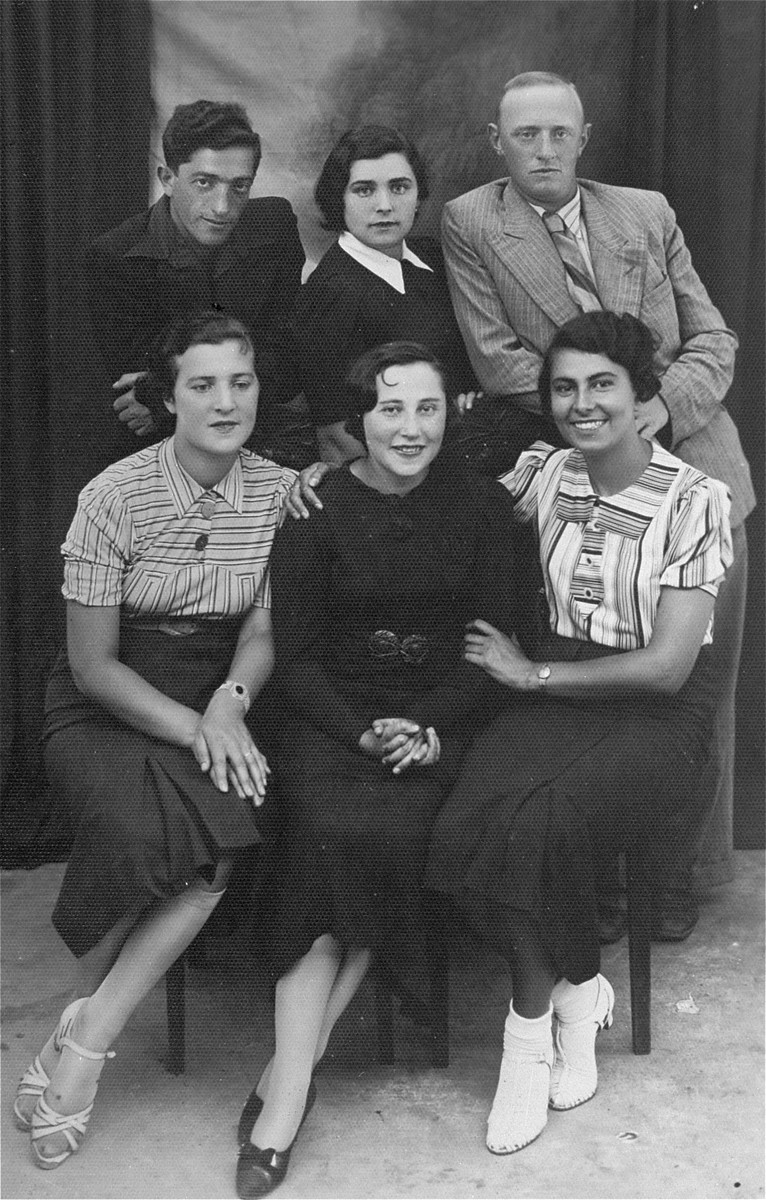 Group portrait of young Jewish men and women in Lithuania. 

Among those pictured are the donor's father, Eliezer Kaplan (top left), and her aunt, Nehama Kaplan (bottom right).