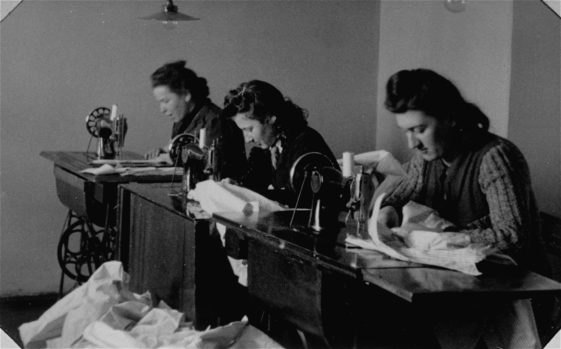 Jewish women work at sewing machines in a workshop in the Bochnia ghetto.