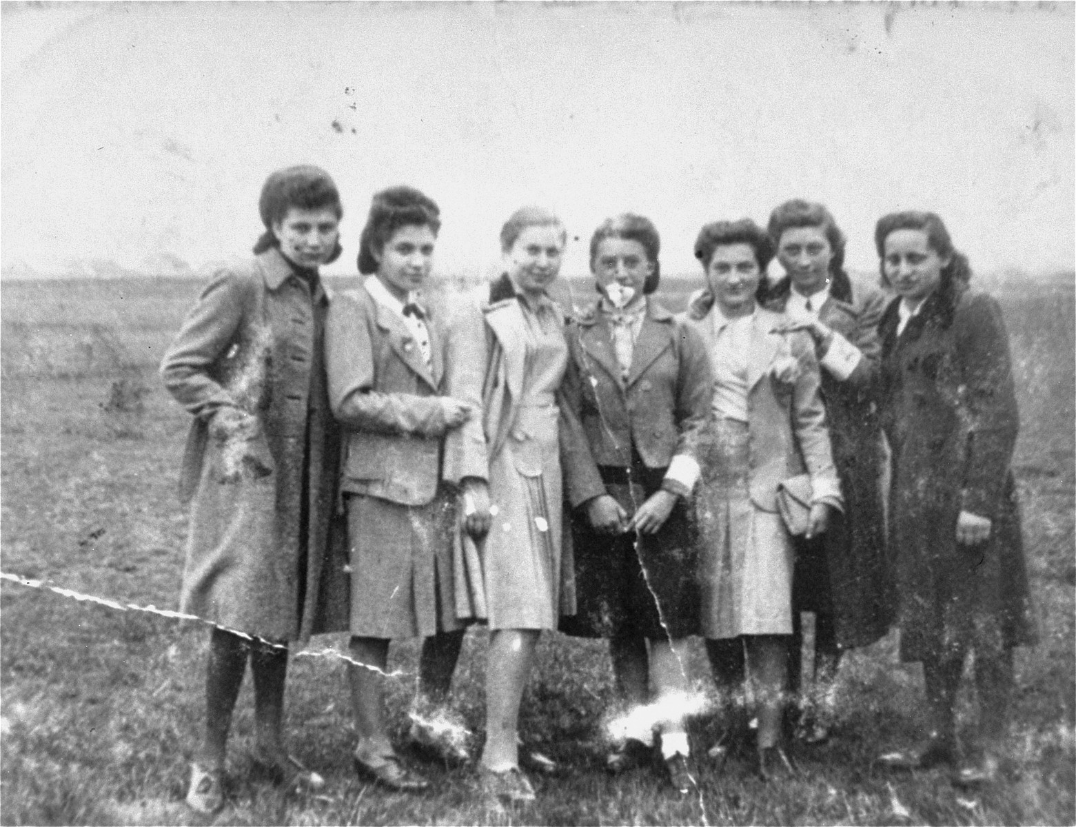 A group of young Jewish women pose in a field in the Chrzanow ghetto. 

Pictured from left to right are: Bronka Wachsberg, Esta Kleiman, Gita Eisenberg, Sabina, Hela Koniecpolska, Hanka Eisenberg and Esta Bochner.
