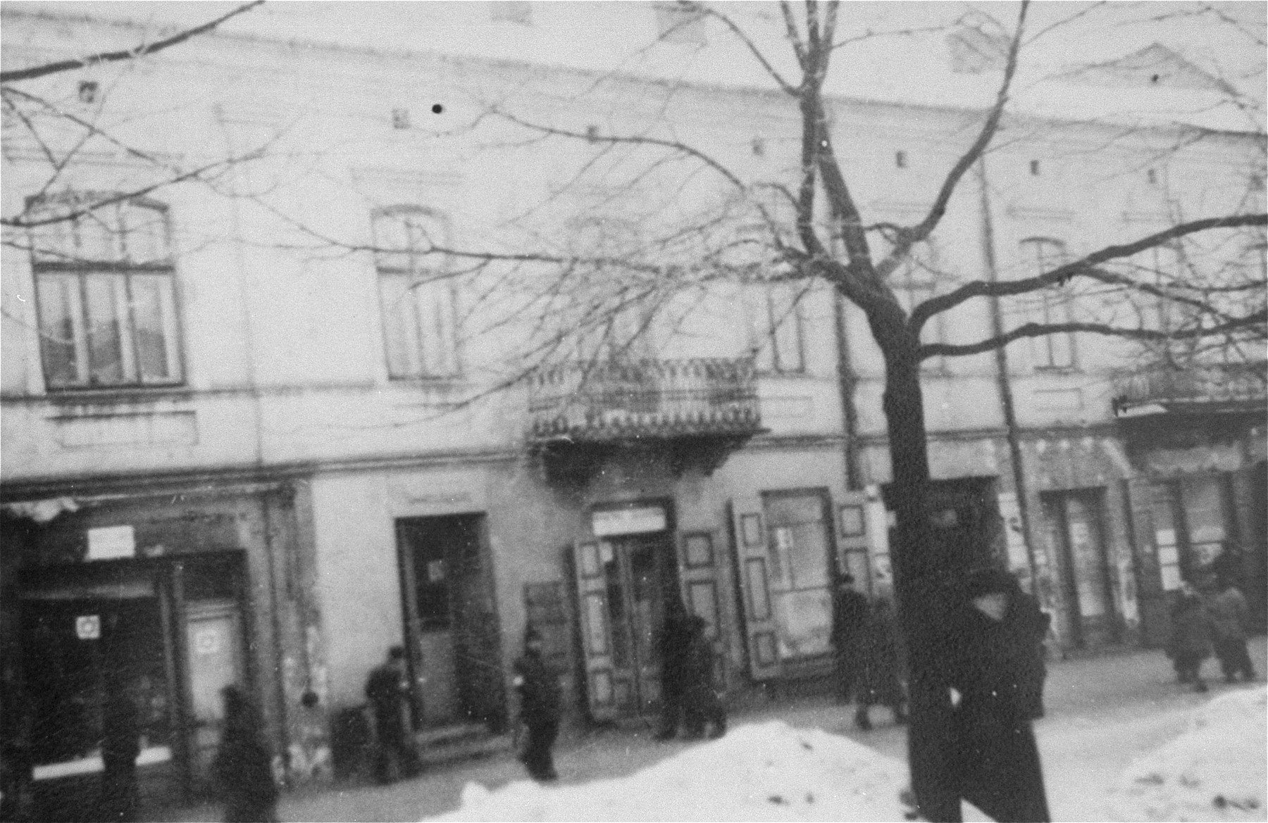 Jews walk along a snow covered commercial street, known as First Aleja Street, in the western part of the Czestochowa ghetto.