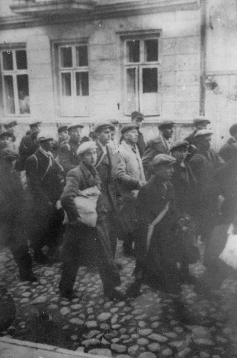 During a deportation action in the Brzeziny ghetto, Jews are marched through town to the railroad station in Galkowek.