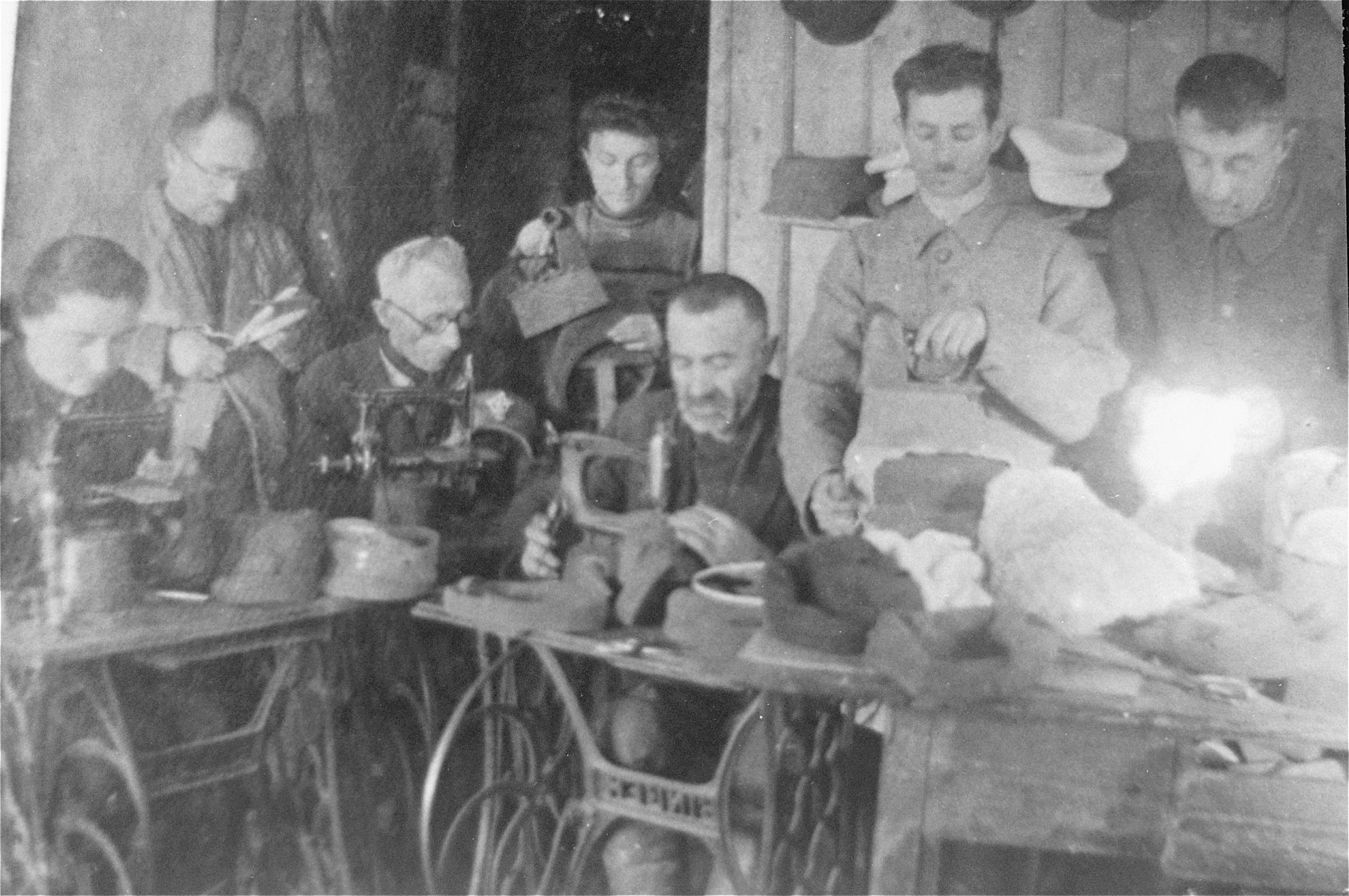 Jews sewing military hats in a workshop in the Glubokoye ghetto.