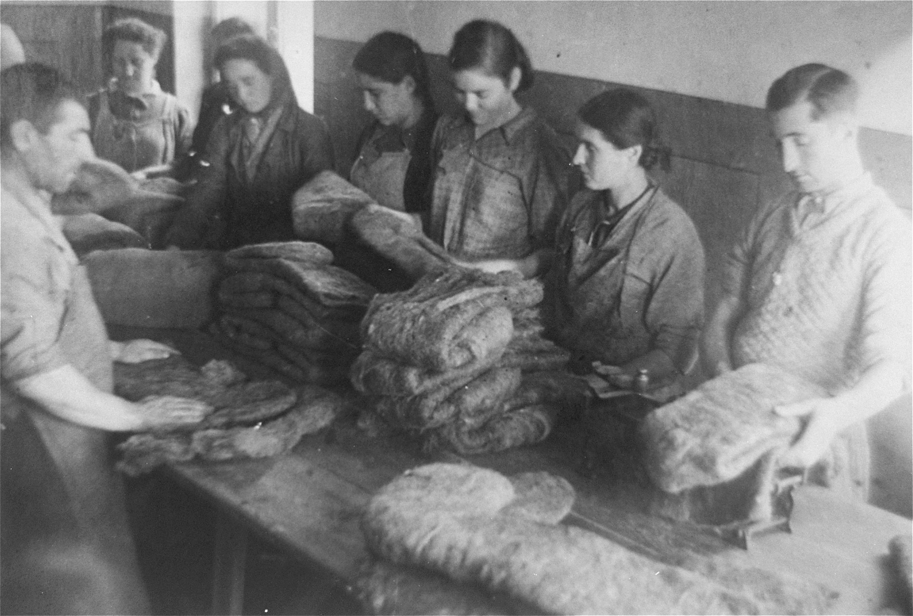 Jewish men and women make felt boots in a workshop in the Glubokoye ghetto.