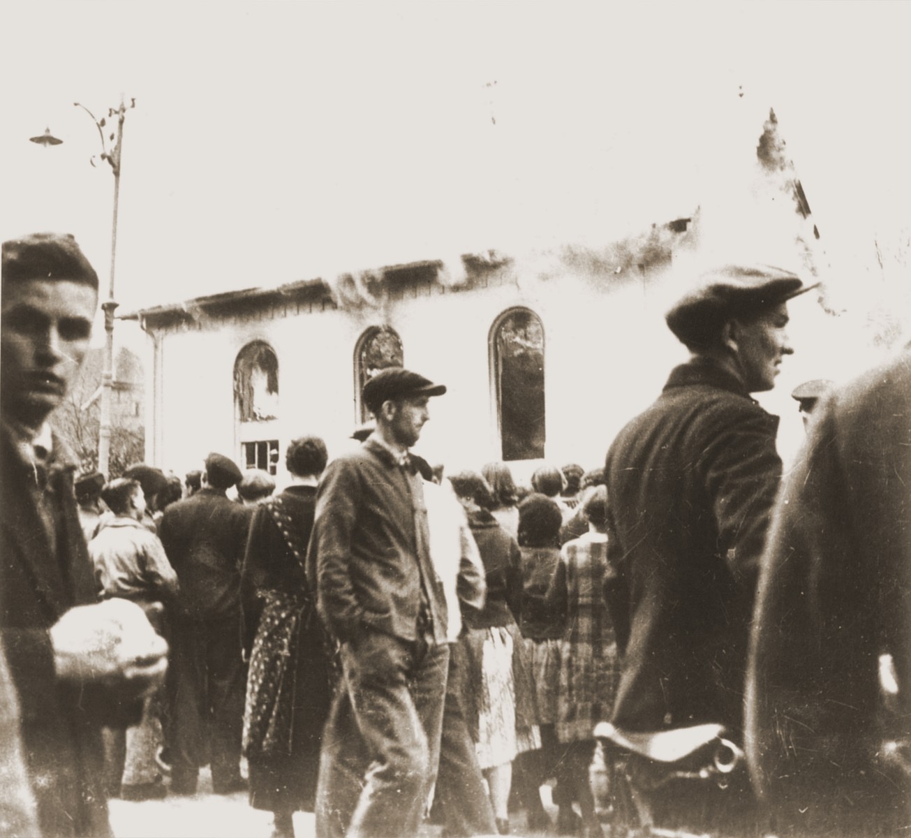 On the morning after Kristallnacht local residents watch as the Ober Ramstadt synagogue is destroyed by fire.   The local fire department prevented the fire from spreading to a nearby home, but did not try to limit the damage to the synagogue.