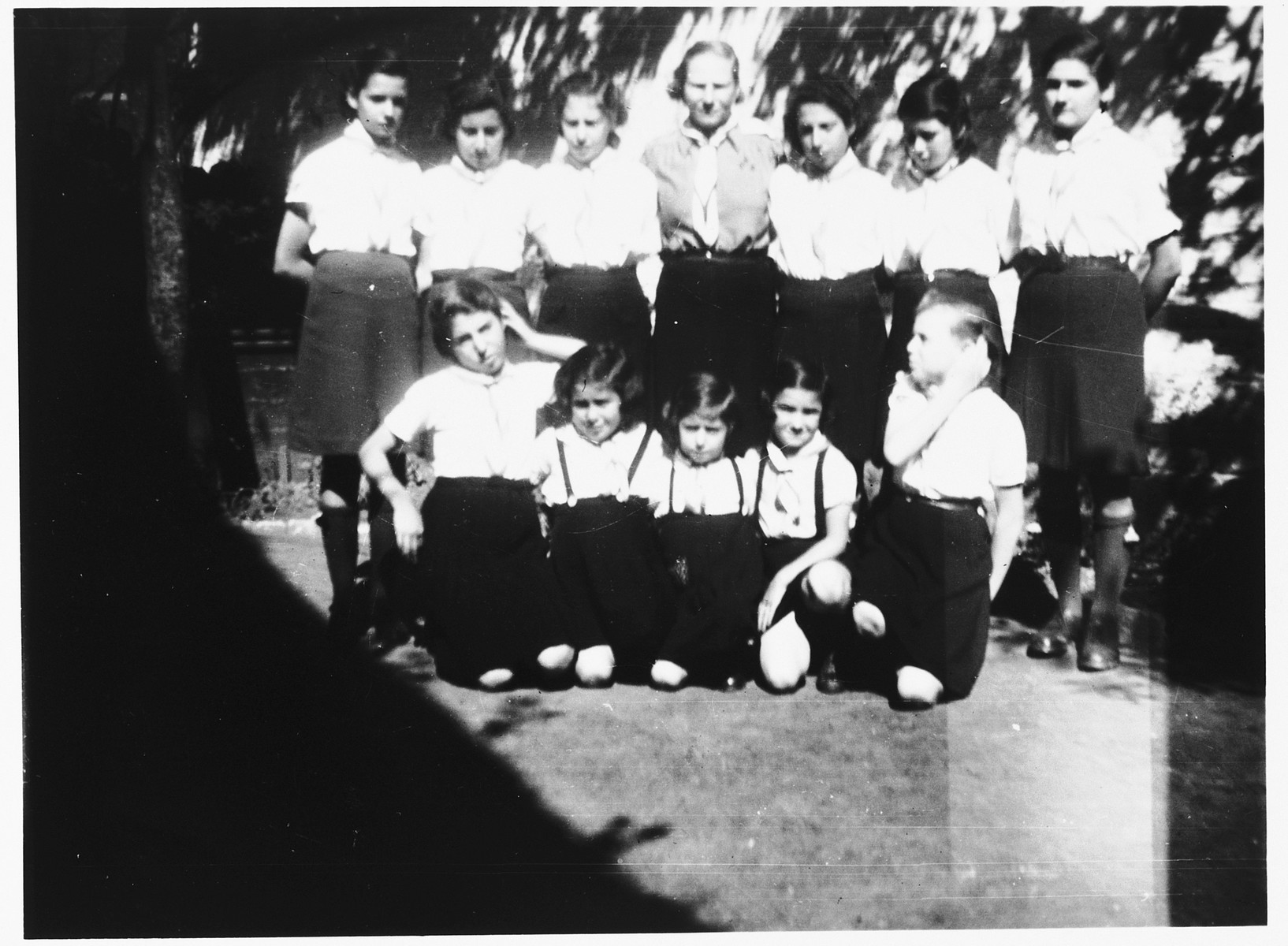 Group portrait of members of the Leah youth group at the Orphelinat Israelite de Bruxelles children's home in the rue des Patriotes.

Among those pictured are: Eva Mozelsio, Rachel, Myriam Neuberger, Rachel Kirschbaum, Edith Greenwald, Ruth Marcus, Bina Gelbart, Helga Somer, and Rachel Sczygielska (back row, second from the right)..