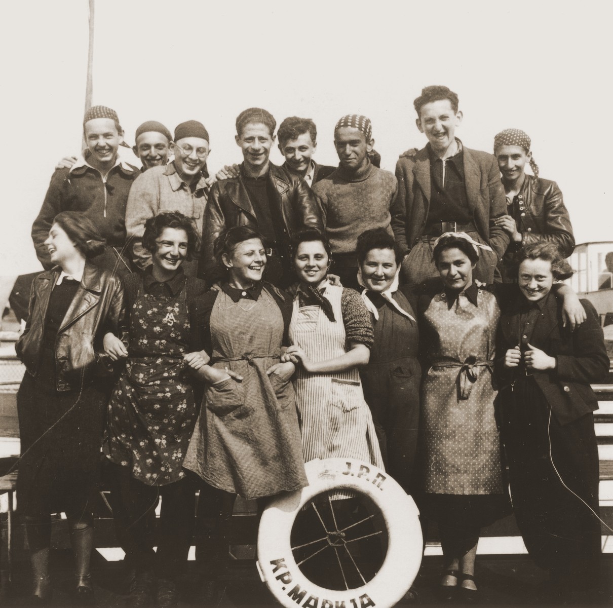 Group portrait of members of the Hashomer Hatzair Zionist youth aboard one of the riverboats (the Kraljica Marija) of the Kladovo transport.

Pictured in the top row from left to right are Zeev Kulka, Josef Cohen, Dov Eshel, Erich Nachhaeuser, Max Stricker, Yehezkel Tanenbaum, Arieh Erez and Avi Marienberg.  In the front row are Margalit Figer, Yael Pagi, Batya Horovitz, Ruth Galilee, Shoshana Dukes, Hannah Rosenwasser and Miriam Pick.