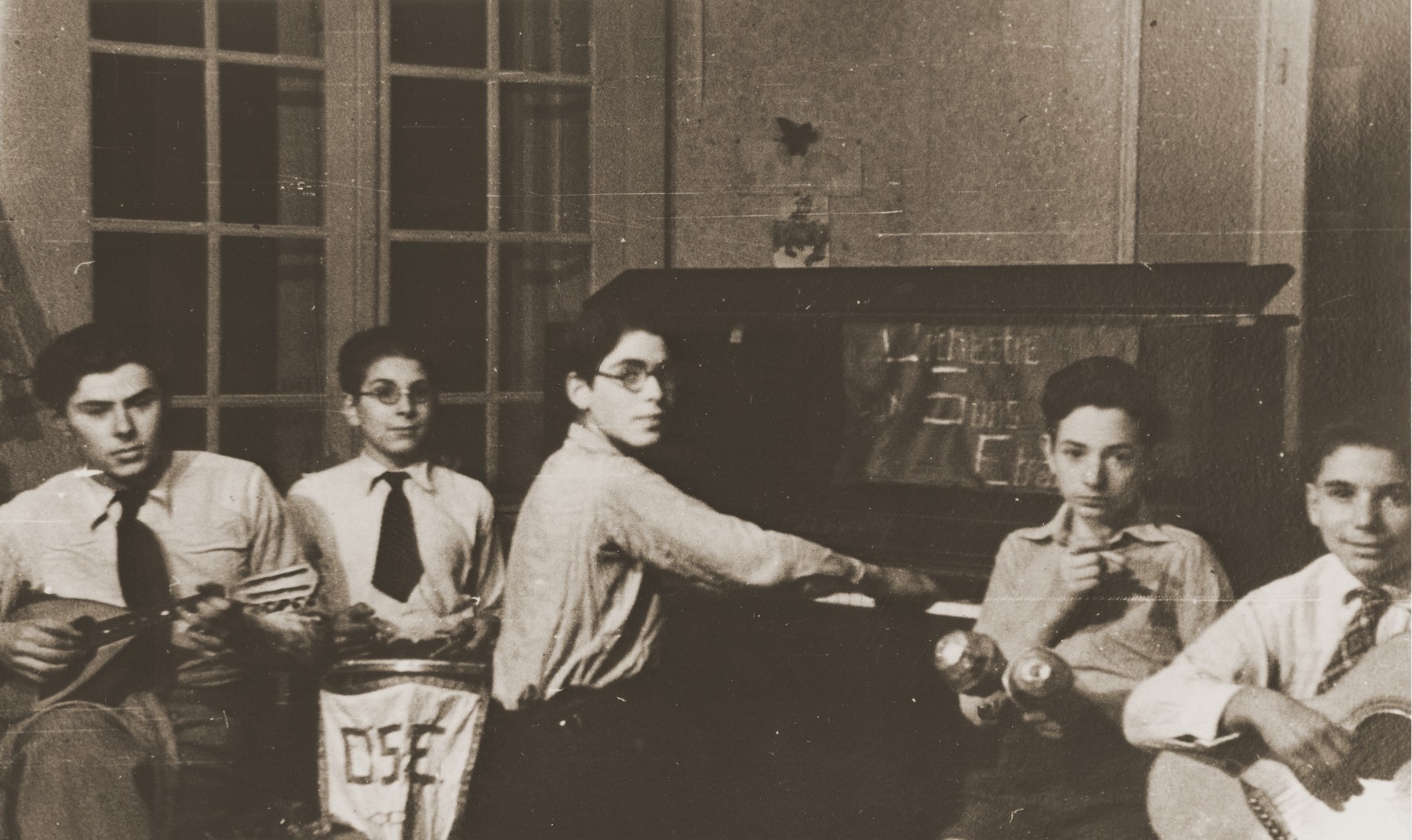 Members of a youth orchestra perform at the Château de Chabannes children's home.  The home was sponsored by the OSE (Oeuvre de secours aux Enfants).

Pictured from left to right are Marjan Szturm, Armand Chochenbaum, Walter Herzig, Gérard Alexander and Peter Marcuse.